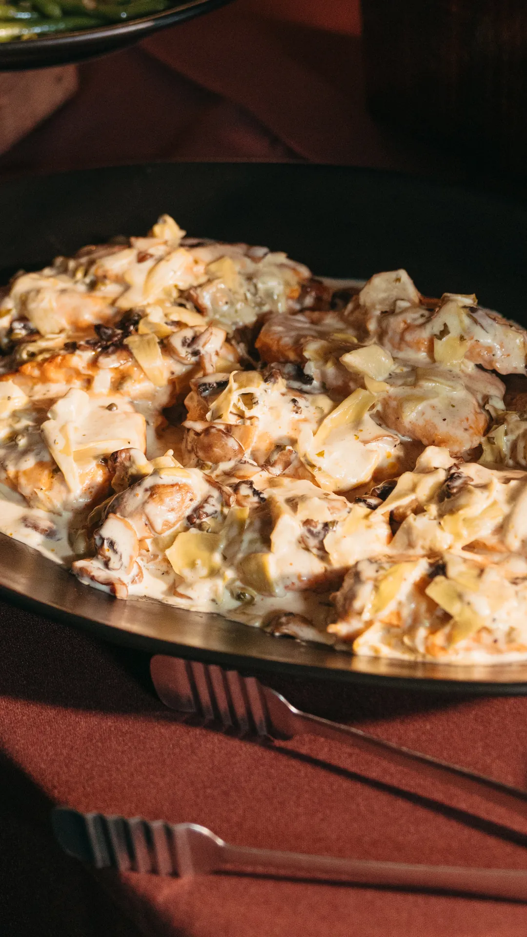 Tray of sliced chicken in a creamy mushroom sauce