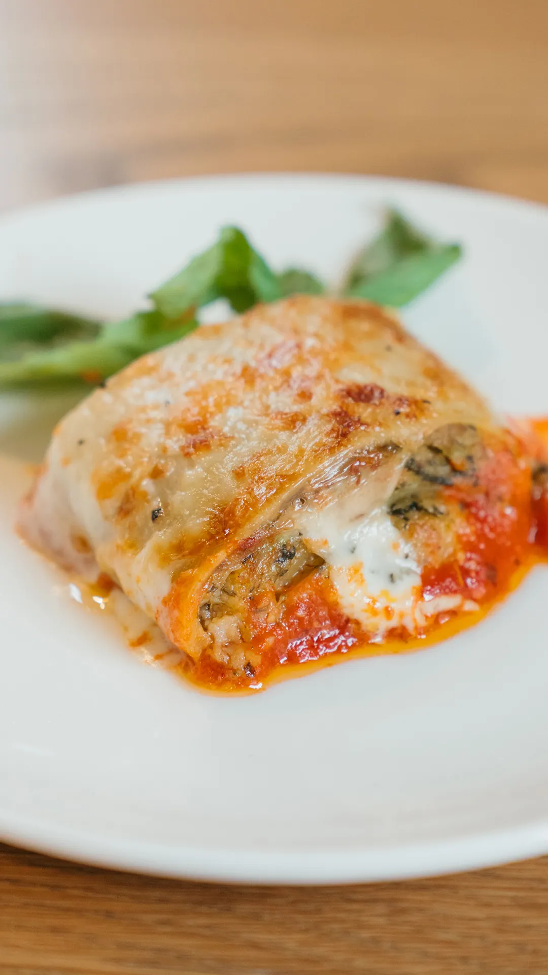 Individual portion of baked pasta with tomato sauce and cheese