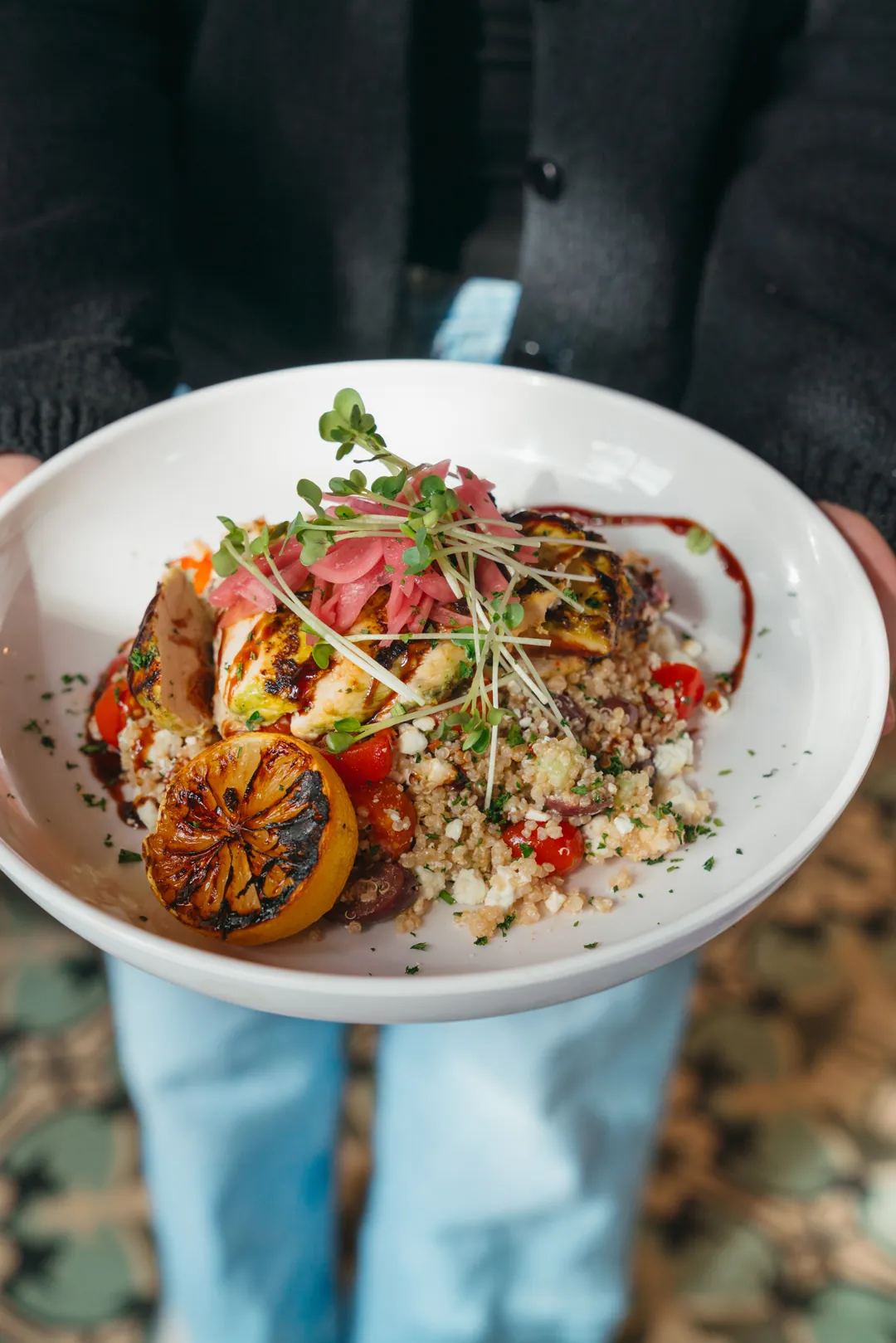 Greek quinoa citrus chicken bowl with pickled onions and grilled lemon
