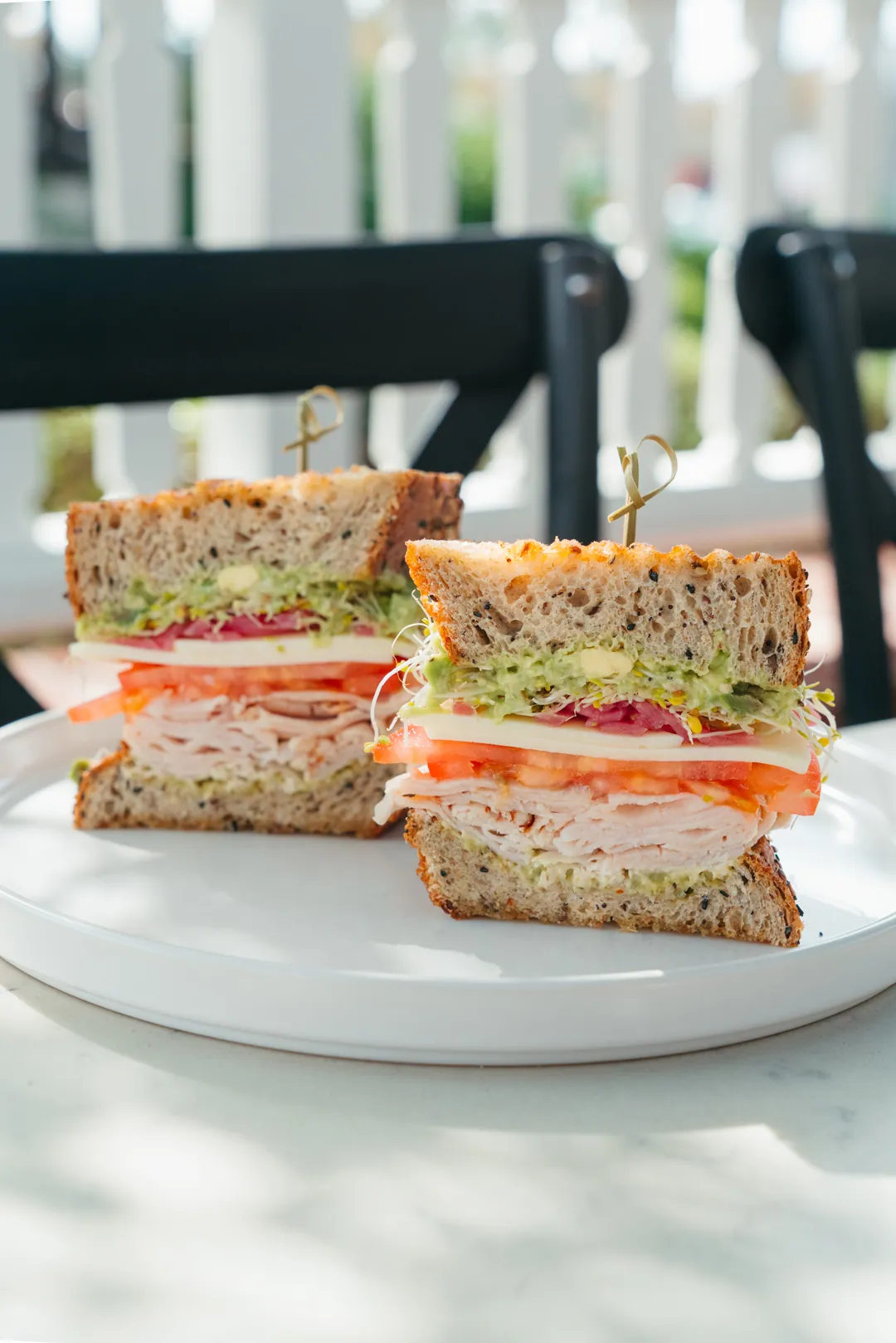 Turkey Delight sandwiches with avocado, tomato, sprouts, and pickled onions