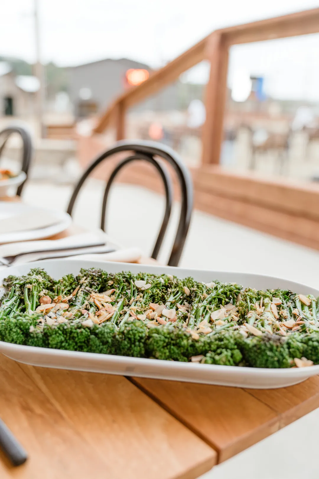 Green salad with grains, nuts, and crumbled cheese on a long white platter