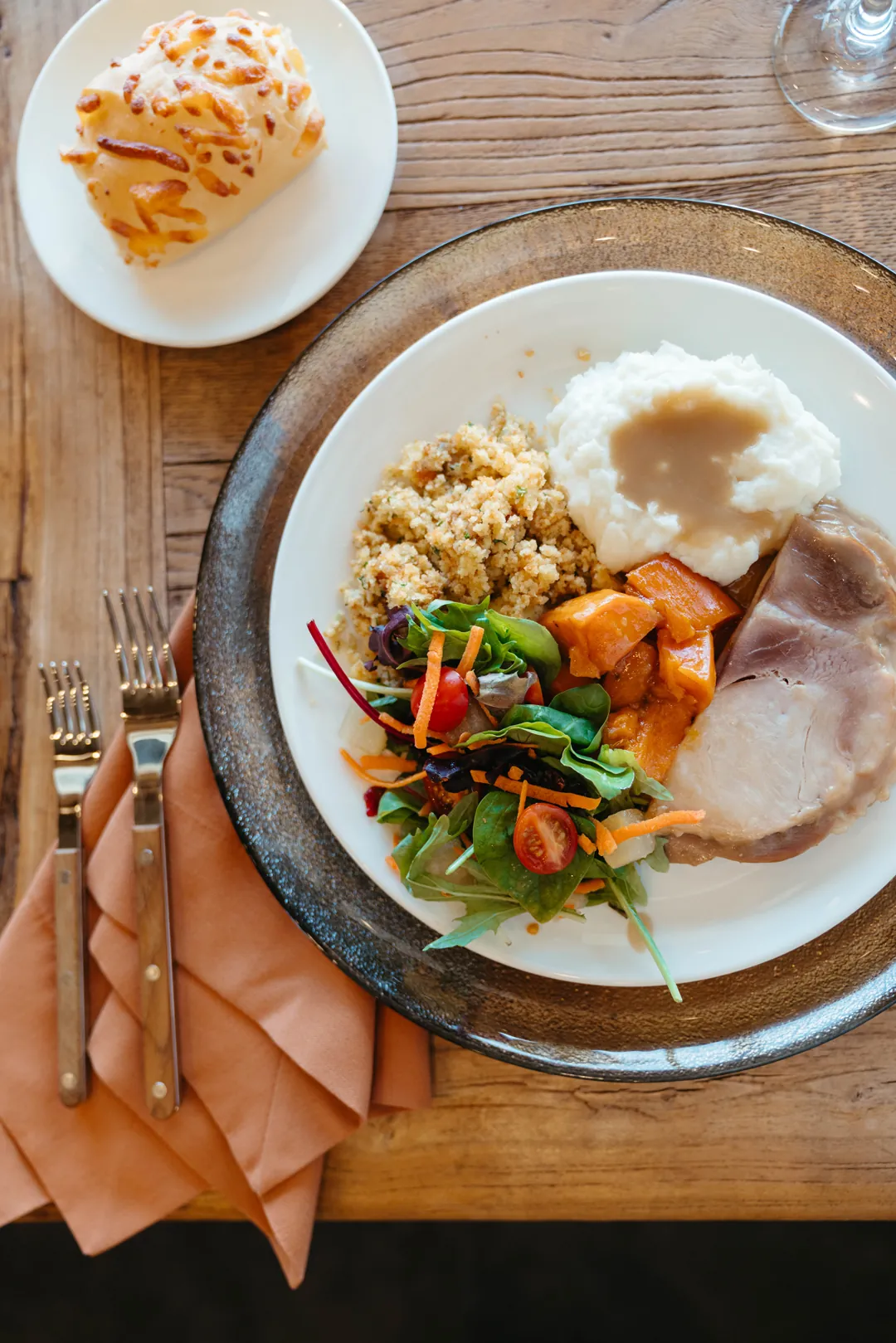 Thanksgiving plate with sliced turkey, stuffing, sweet potatoes, green beans, and gravy
