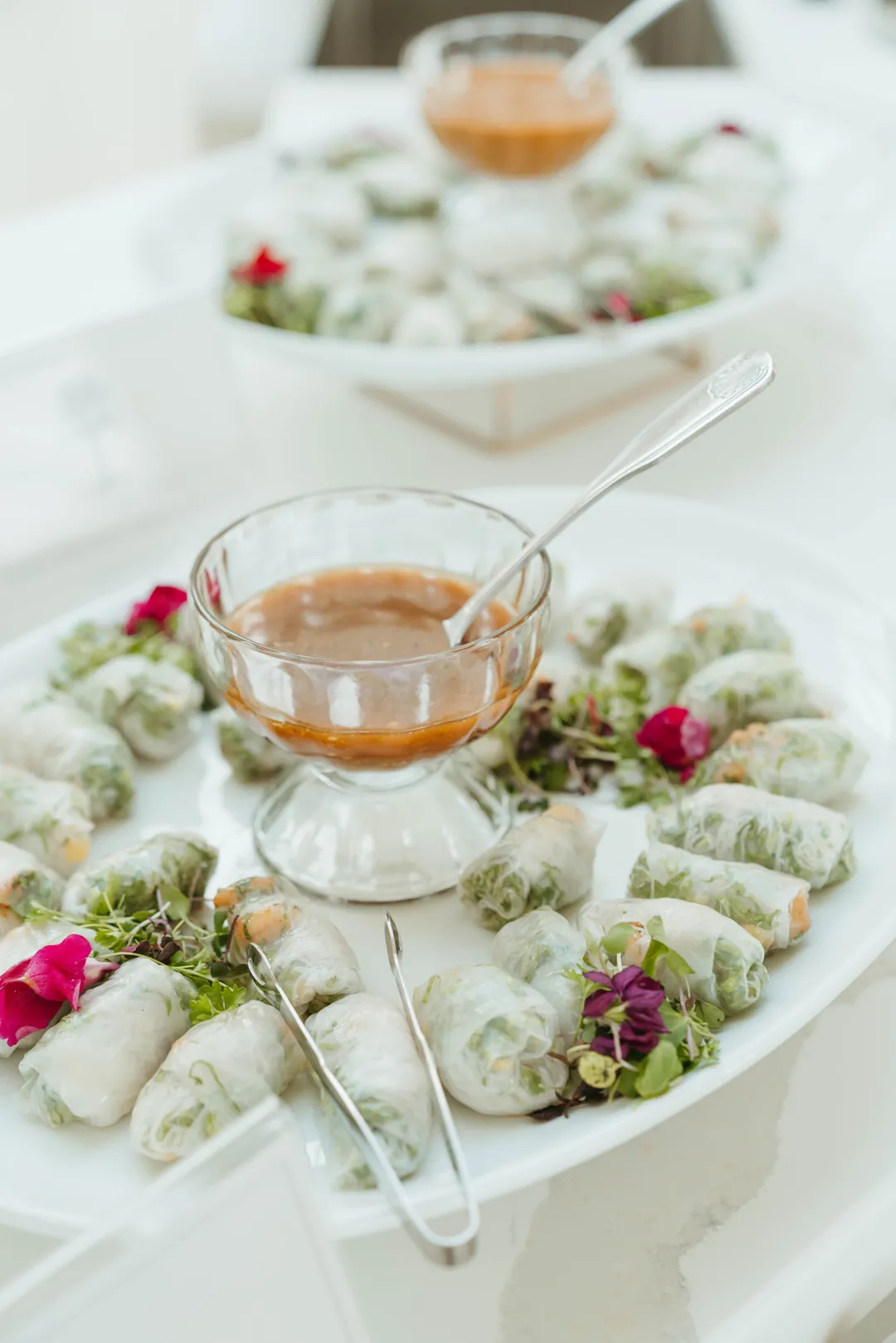 Fresh spring rolls arranged around a bowl of dipping sauce