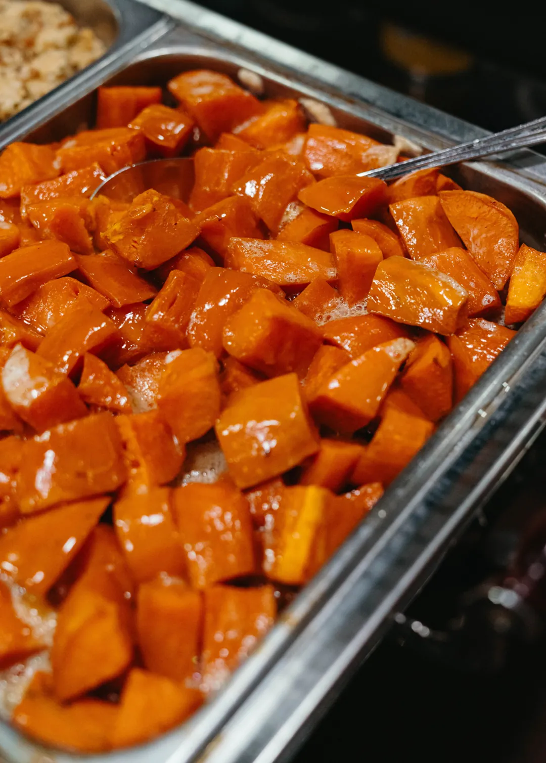 Glazed sweet potato pieces in a buffet pan