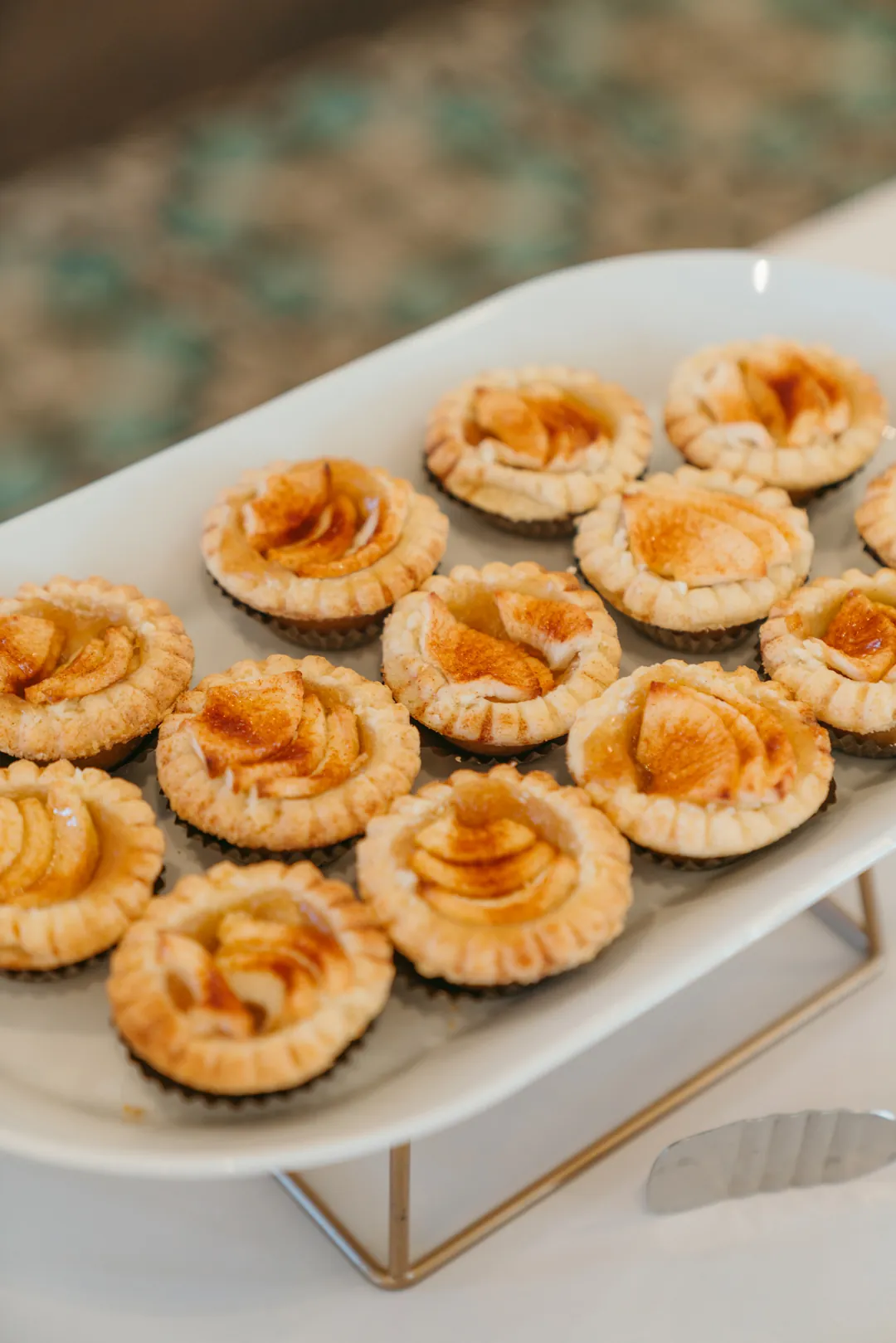 Tray of individual pumpkin tartlets with piped crust