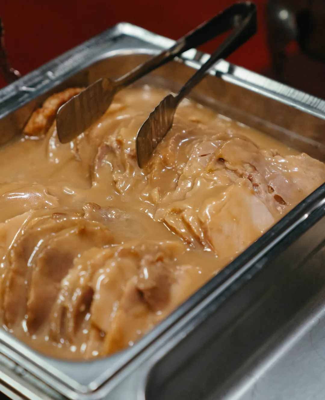 Sliced turkey in gravy in a buffet pan