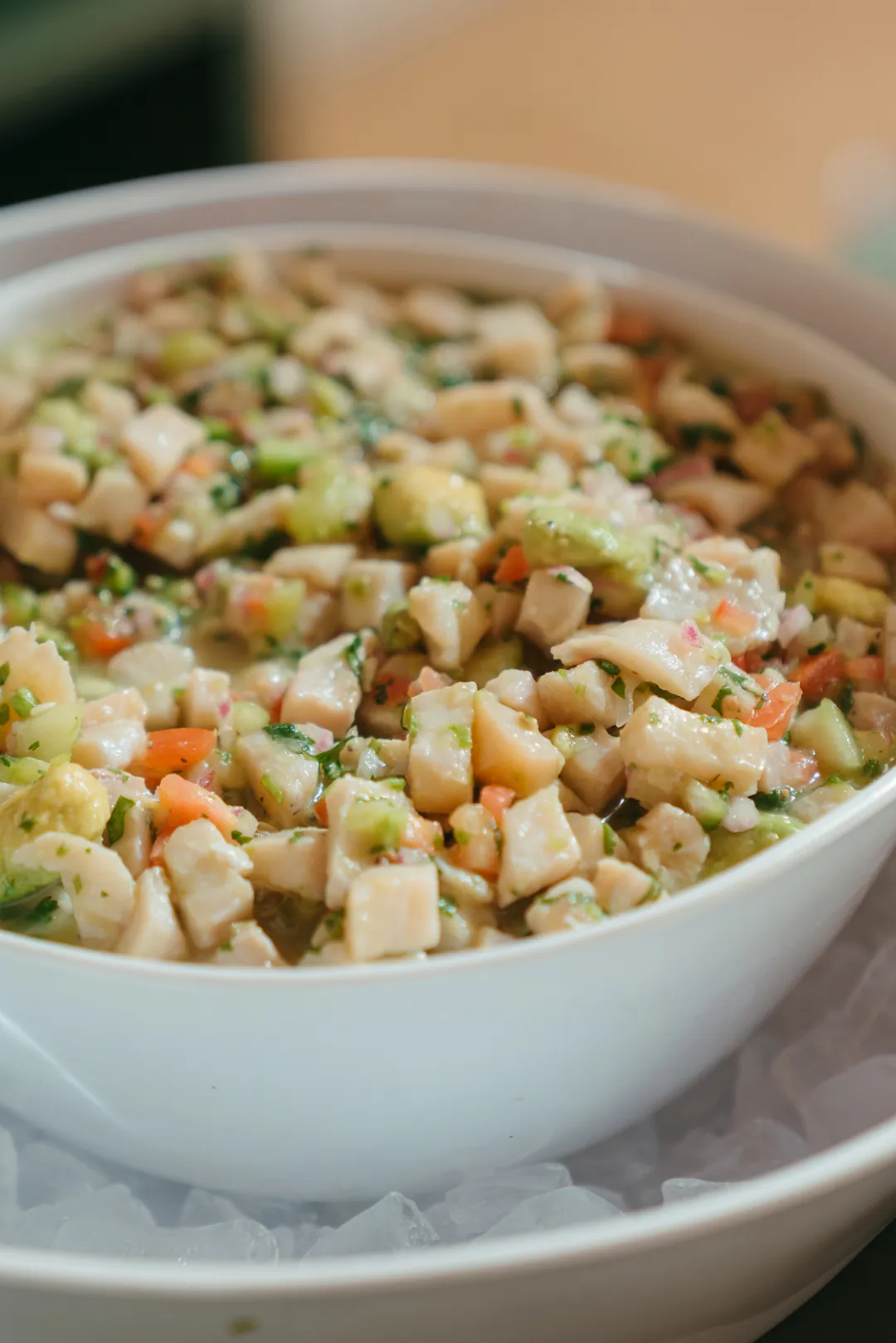 Diced cucumber and vegetable salad in a white bowl