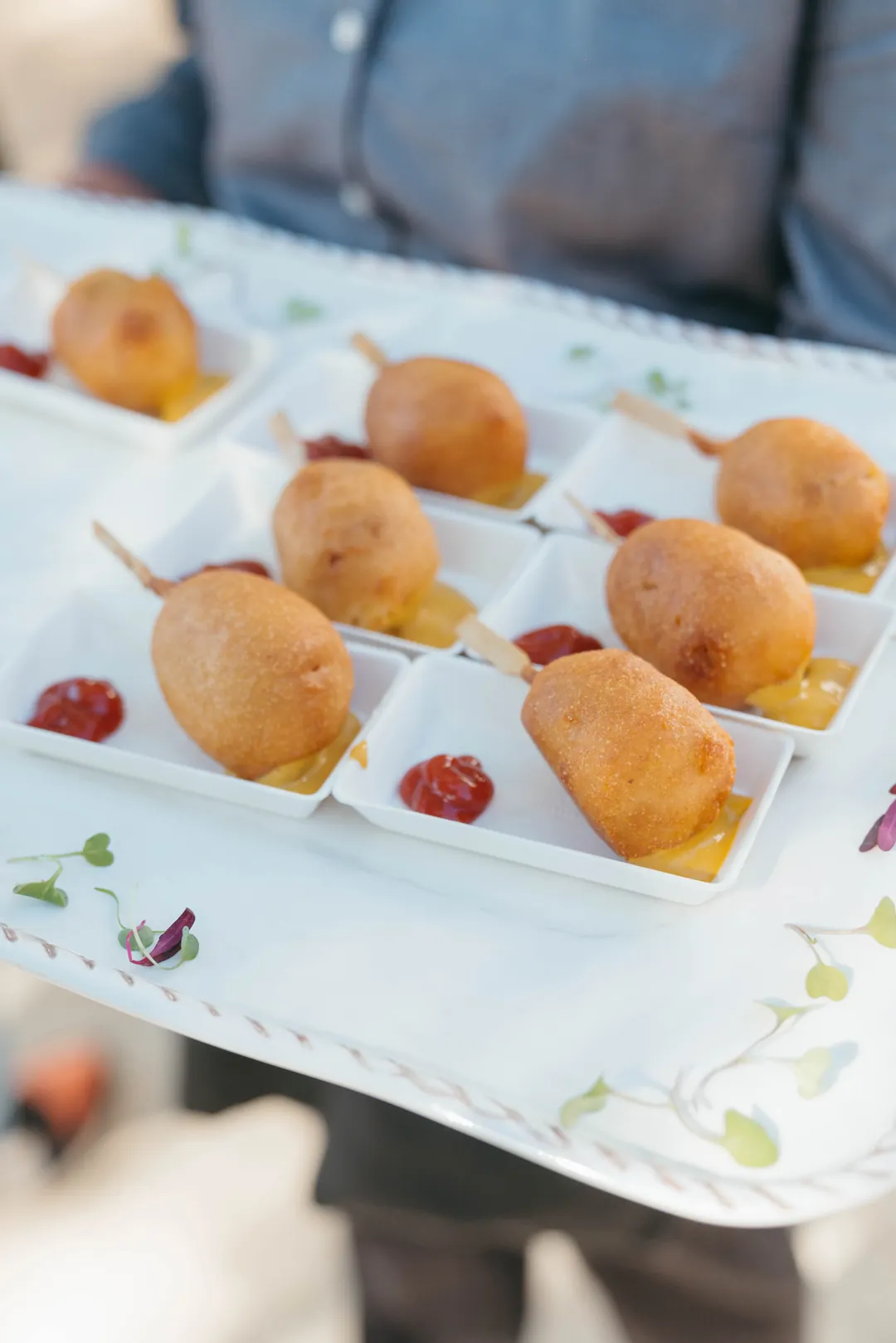 Bite-size corn dogs served with red and yellow dipping sauces