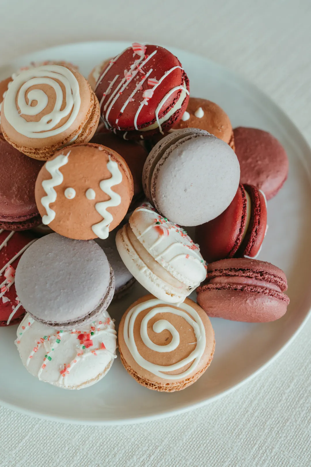 Assorted decorated macarons in a white bowl