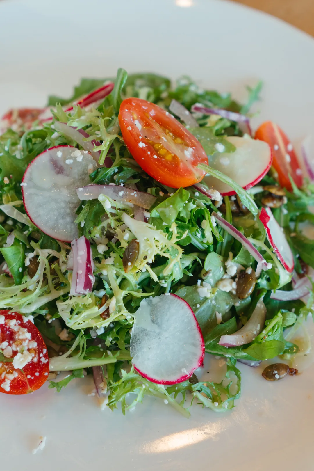 Mixed green salad with cherry tomatoes and radish slices