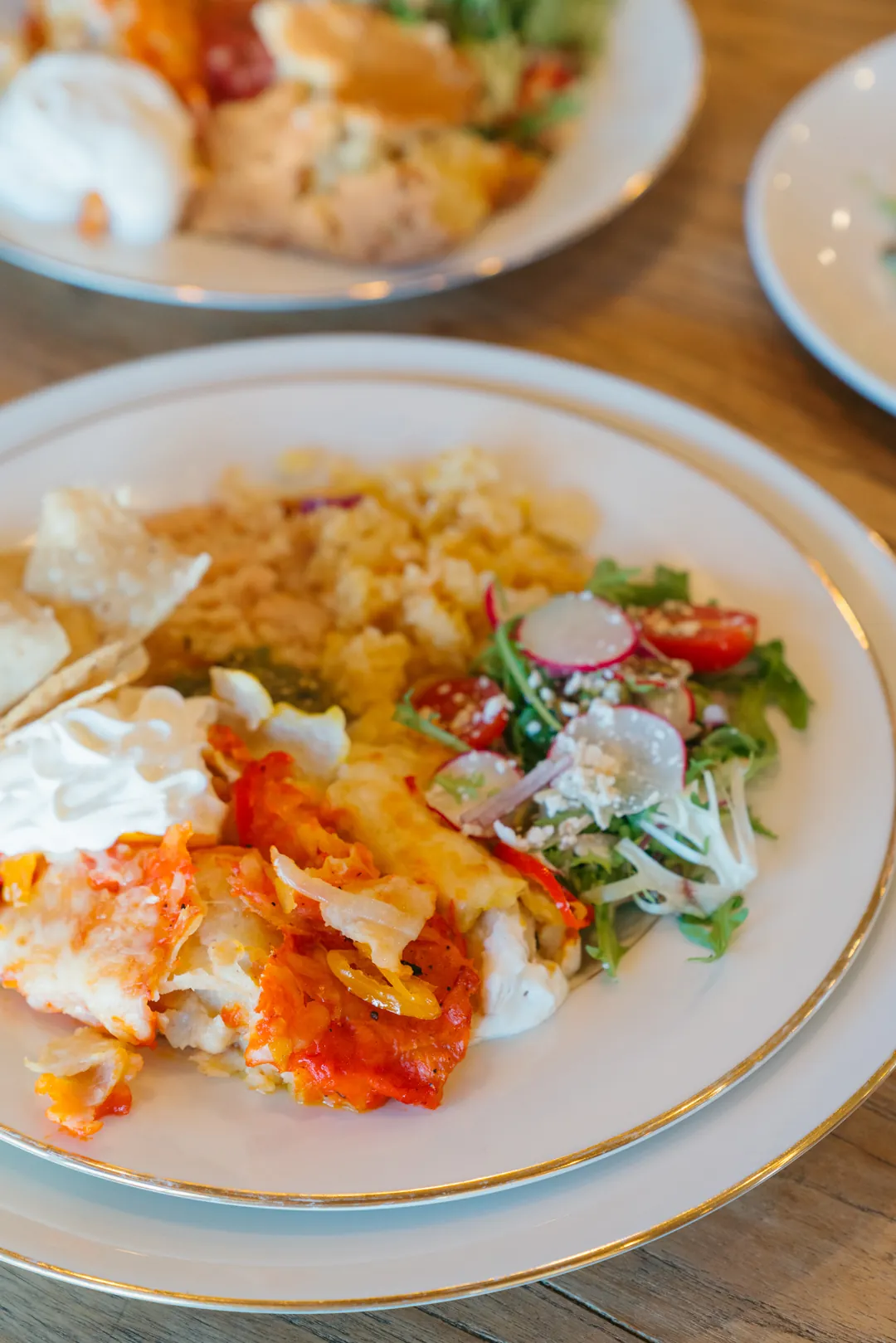 Plate with baked pasta, rice, and a mixed green salad