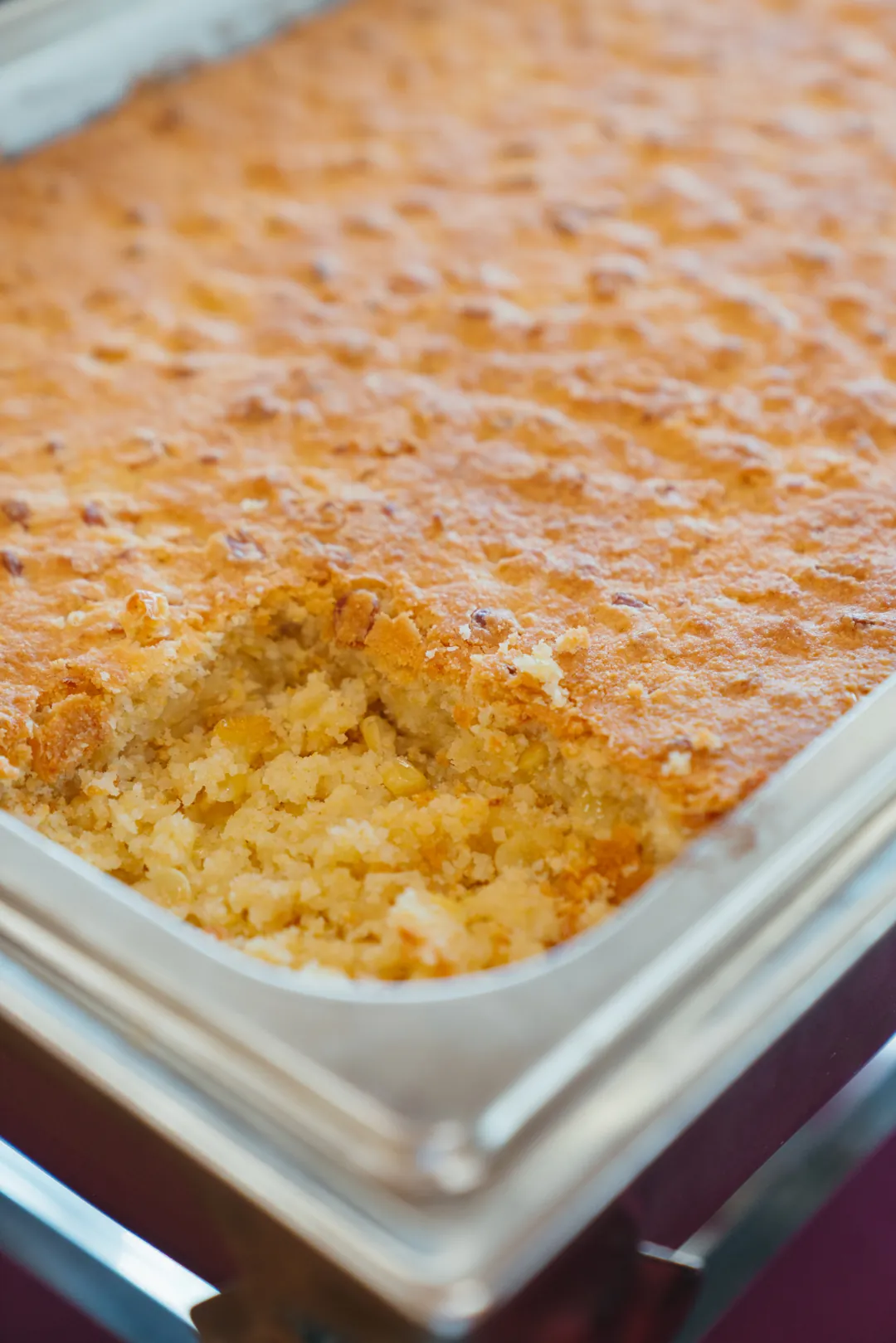 Golden baked corn casserole in a buffet pan
