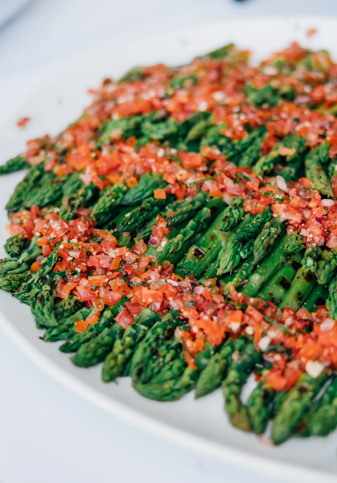 Roasted asparagus topped with diced tomatoes and herbs