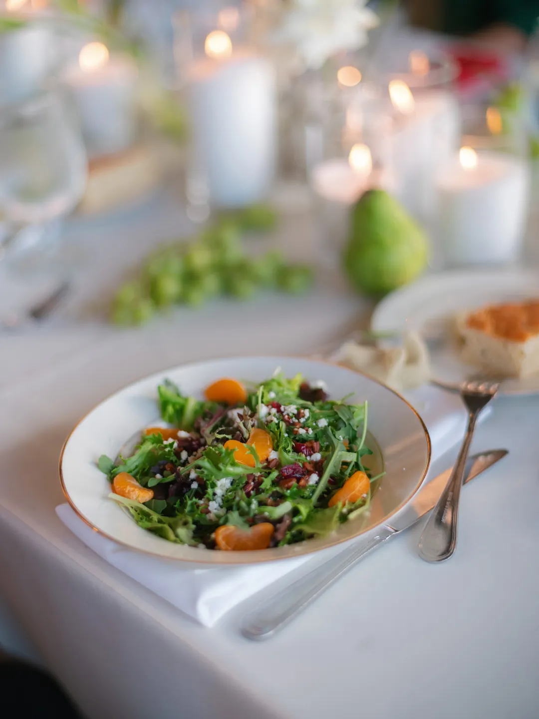 Mixed green salad served at a candlelit reception table