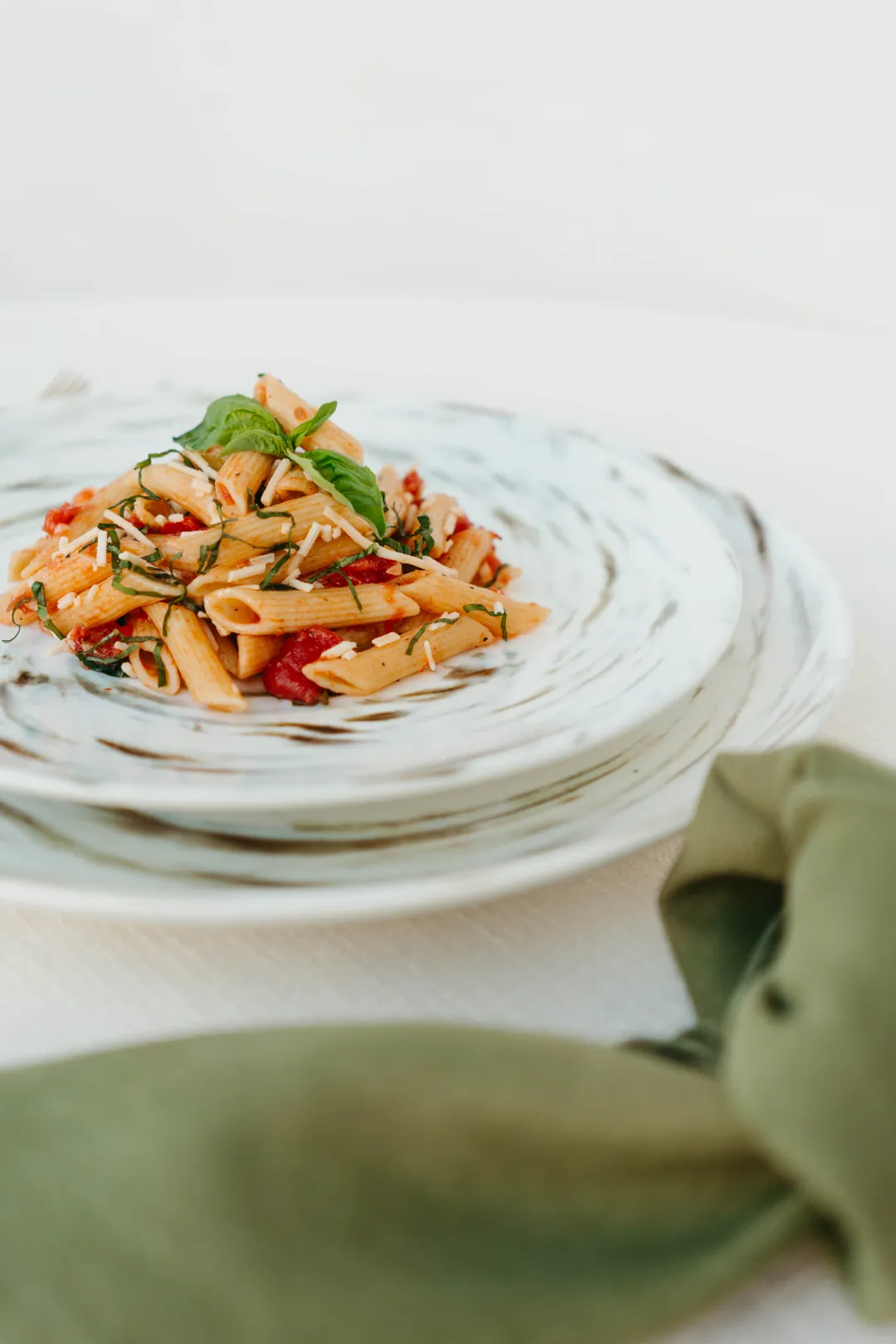 Penne pasta with tomatoes, herbs, and grated cheese