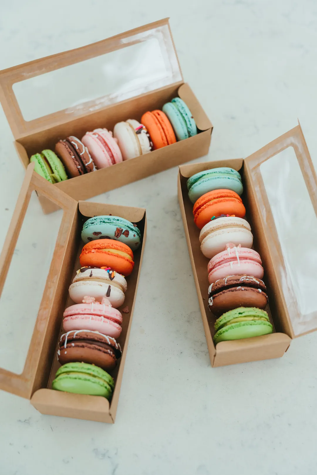 Summer macarons arranged in three wooden gift boxes