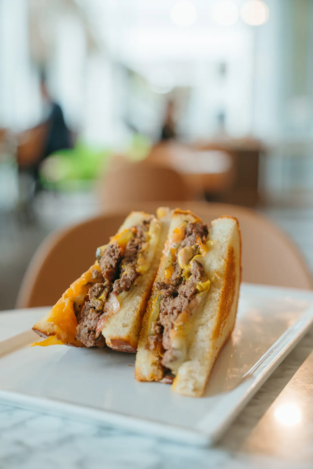 Patty melt cut in half on a white plate