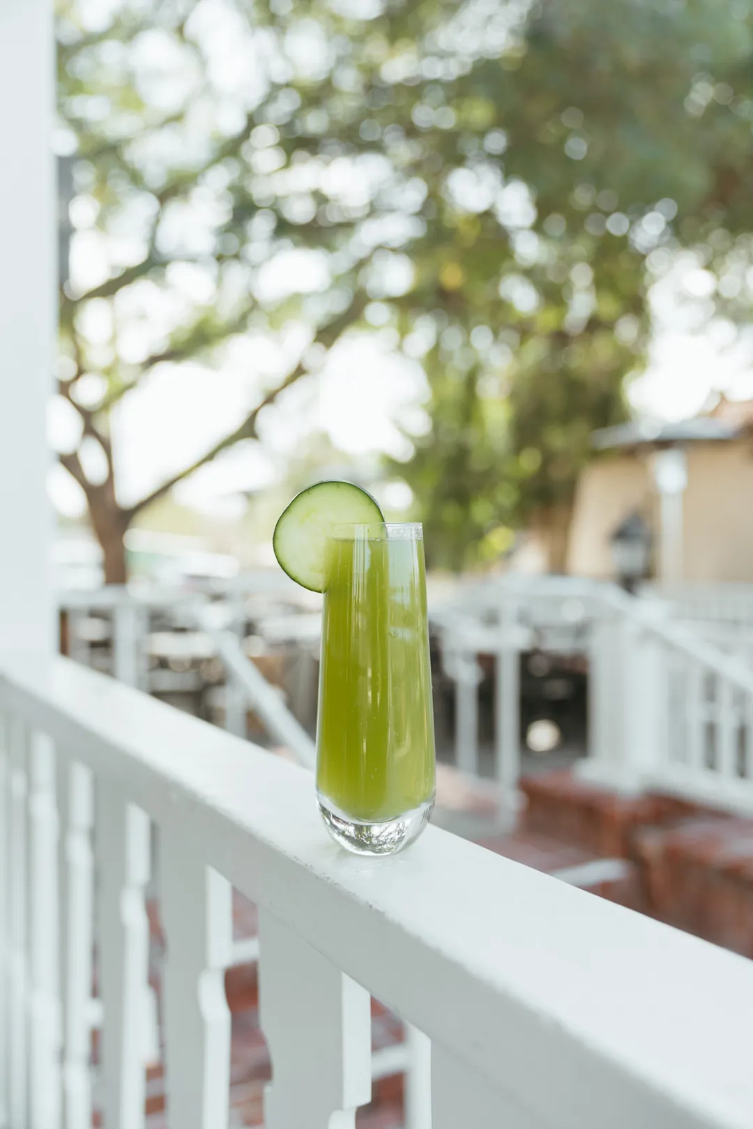 Lucky mimosa with a cucumber garnish on the patio railing