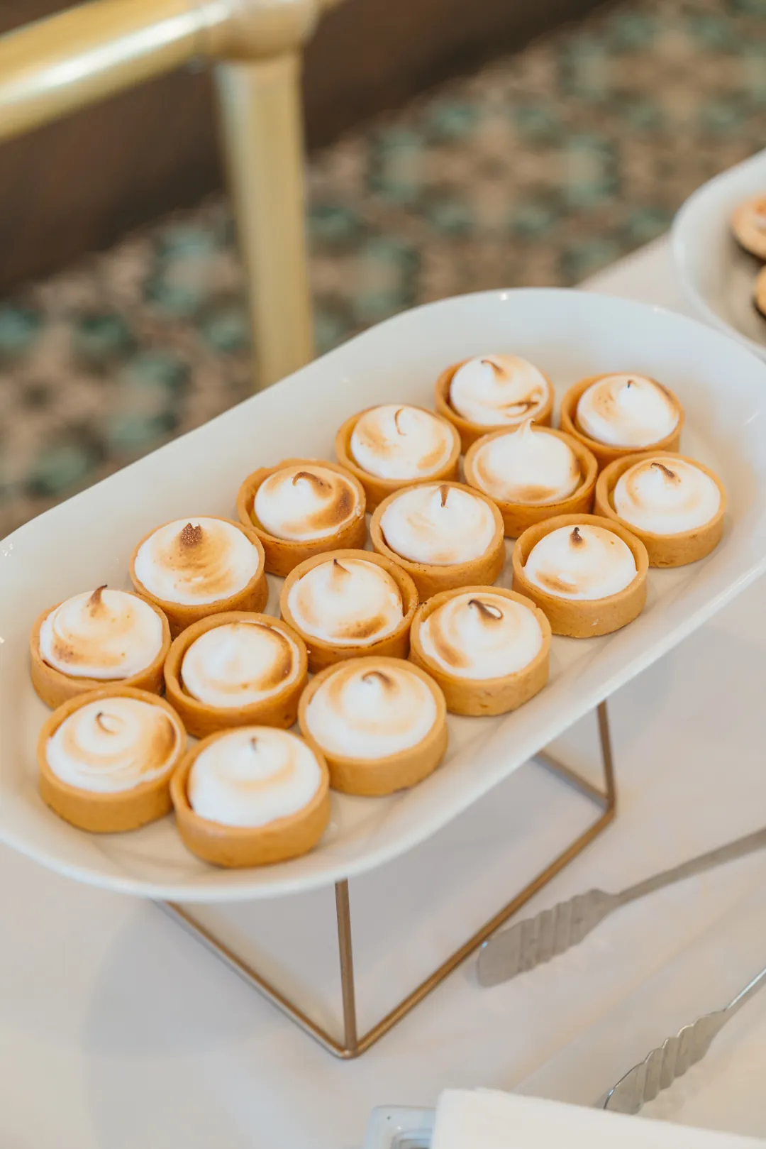 Lemon meringue tarts on a white platter