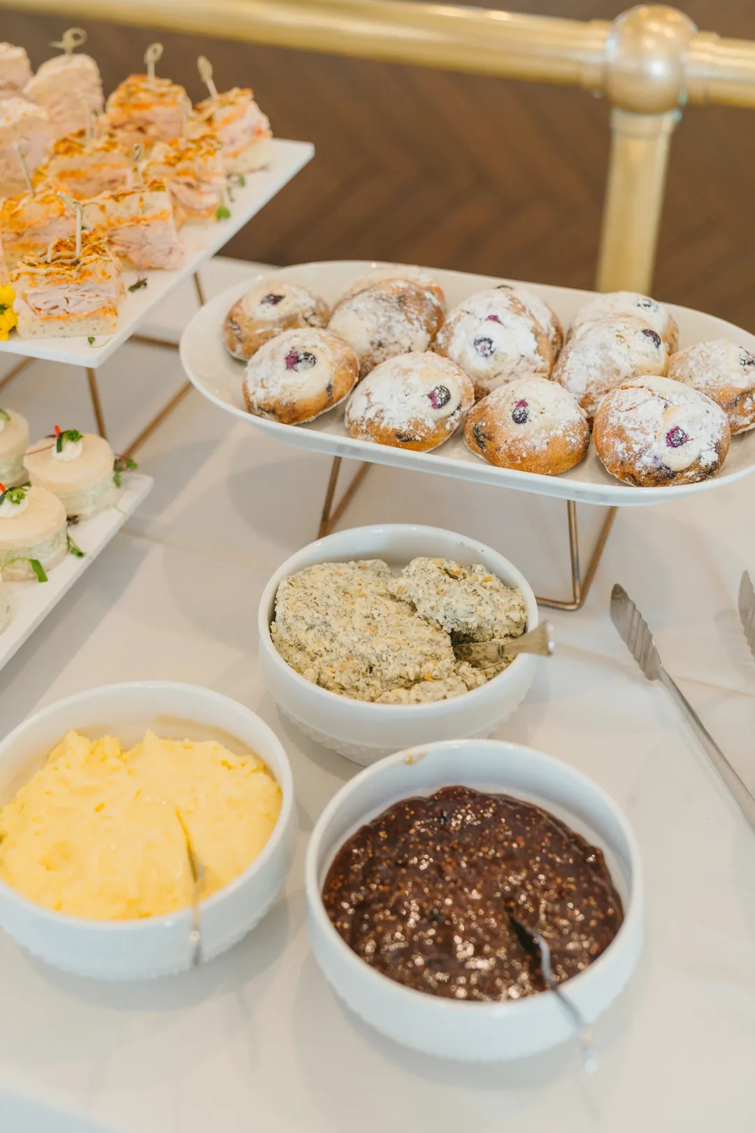 Powdered berry pastries beside small bowls of spreads