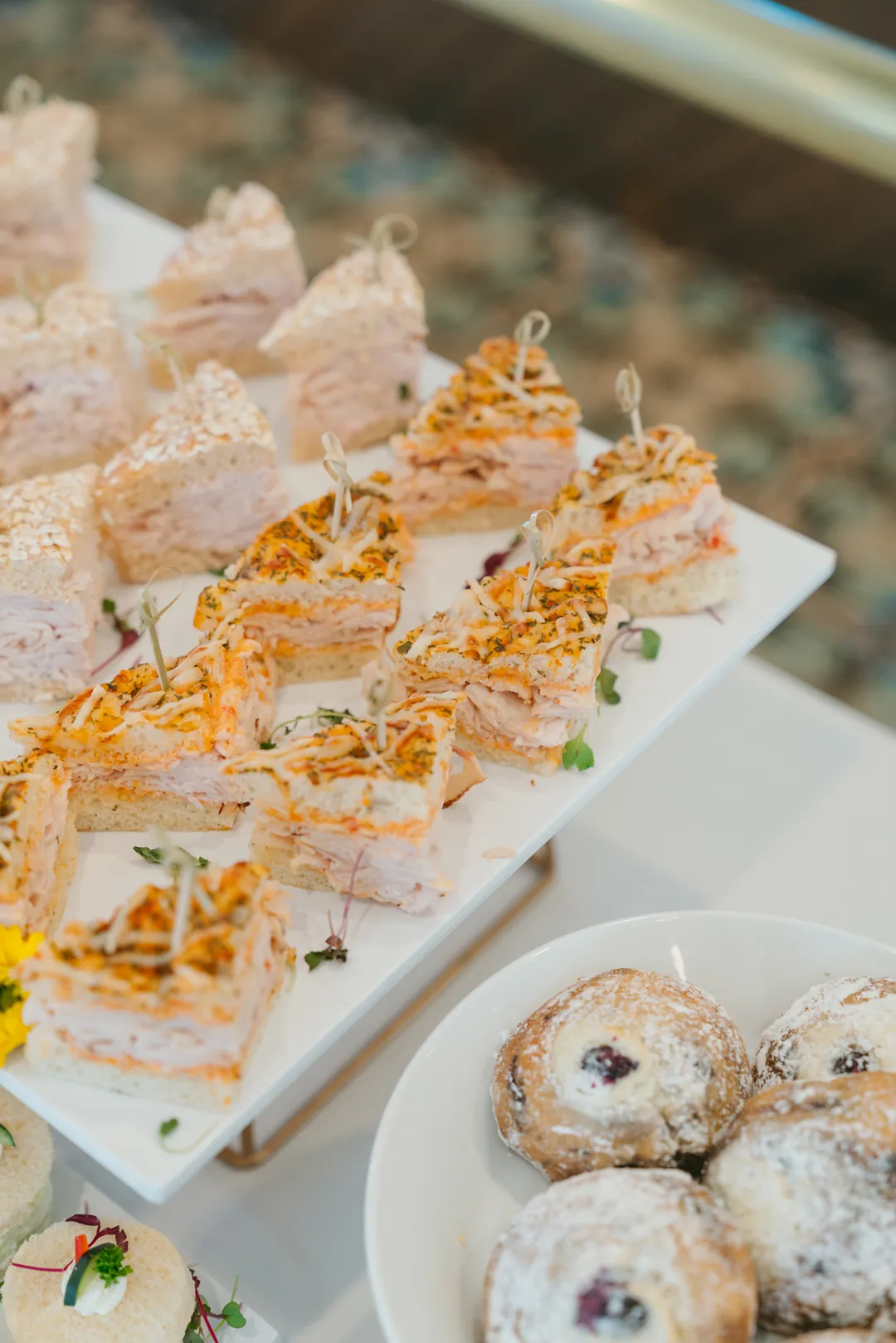 Turkey focaccia sandwiches beside powdered berry pastries