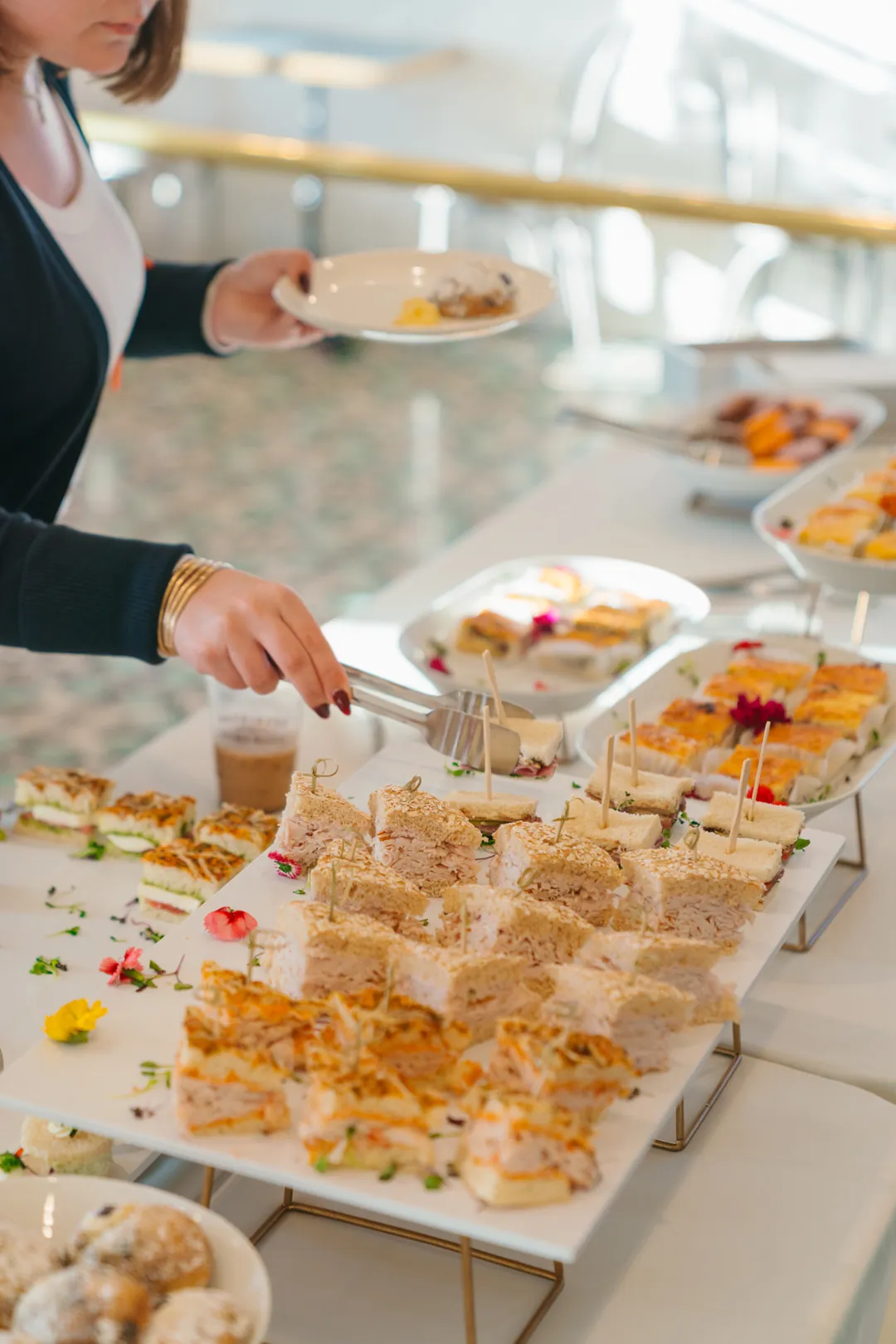 Guest serving tea sandwiches from the buffet