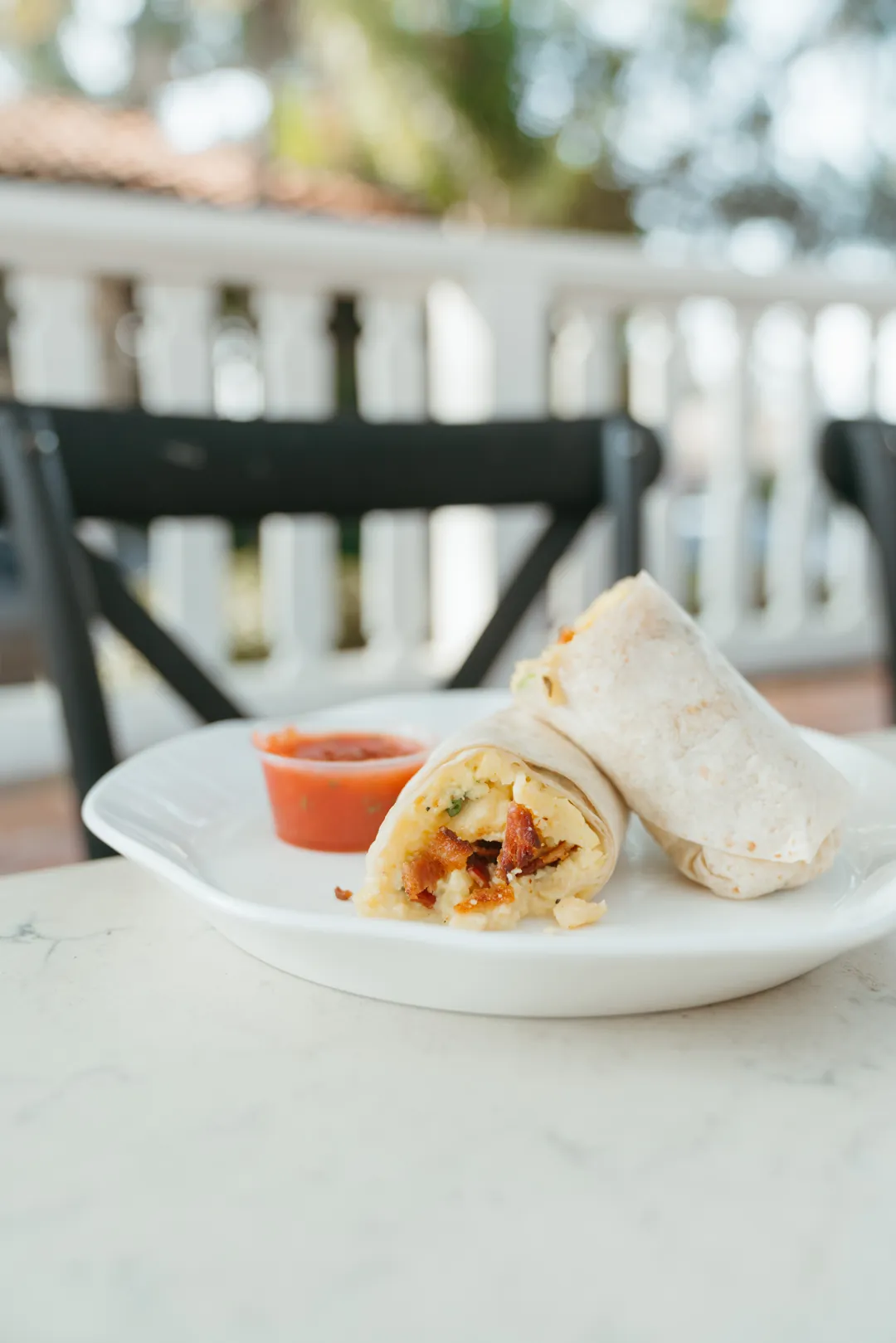 Egg and bacon breakfast burrito with salsa