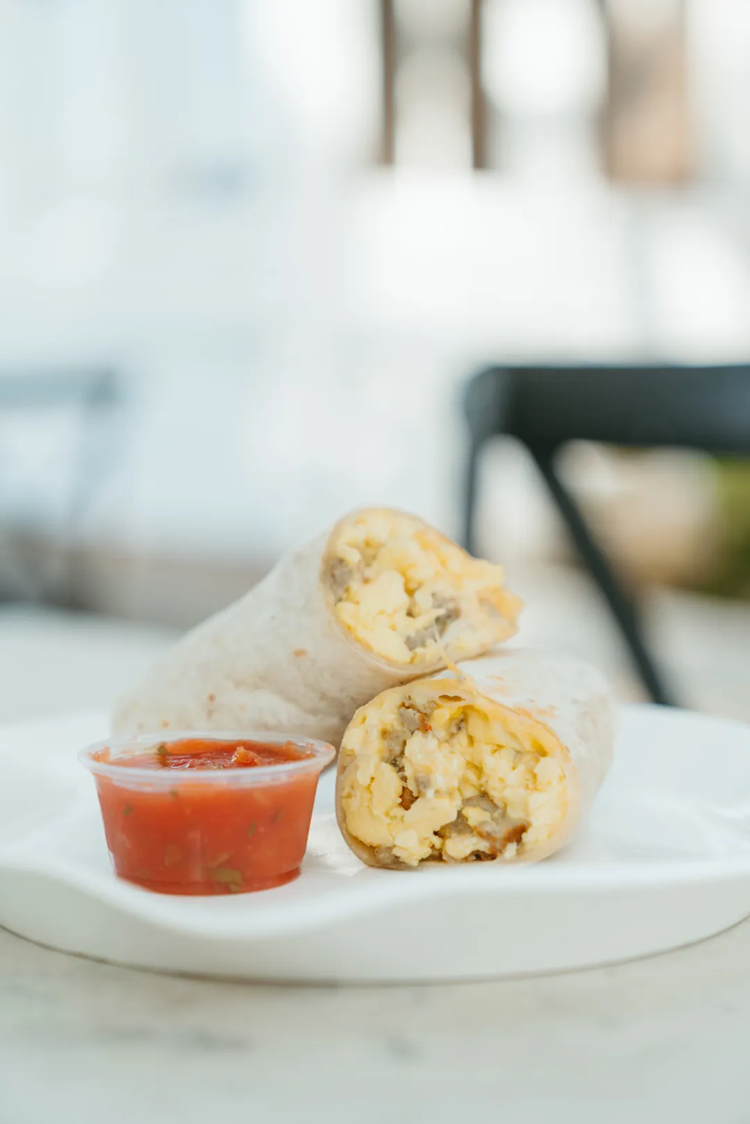 Egg and sausage breakfast burrito with salsa