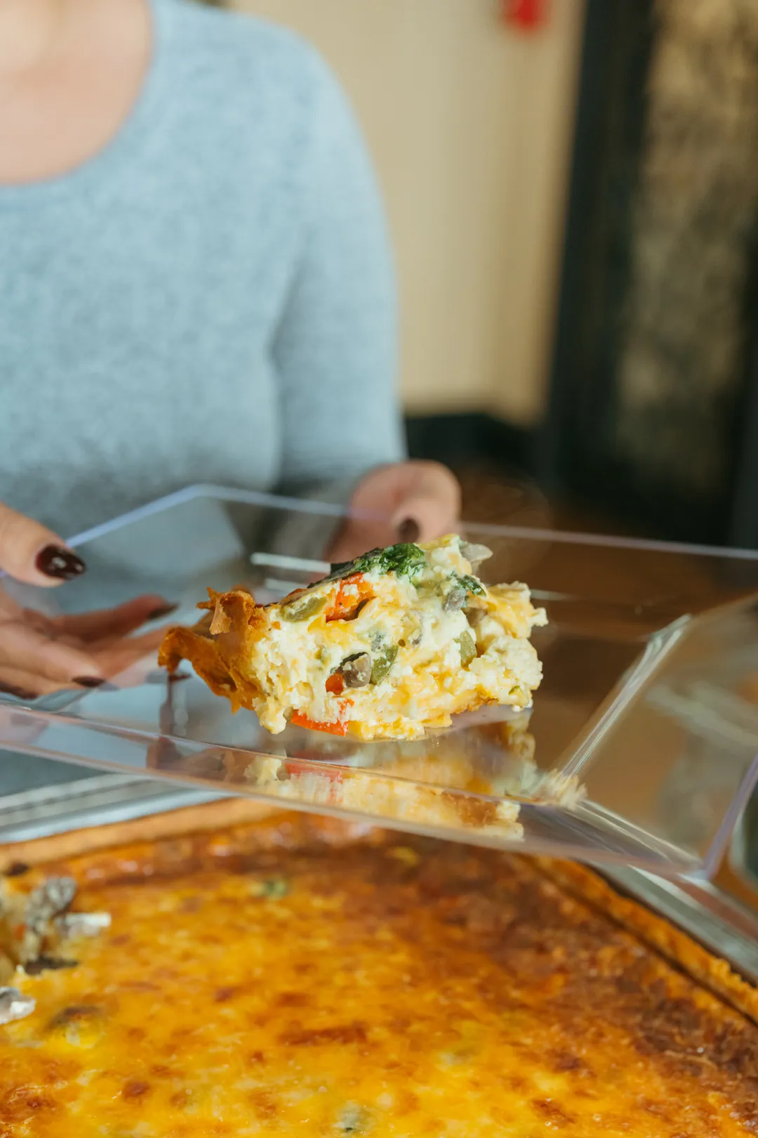 Vegetable deep-dish quiche slice with spinach, mushrooms and peppers