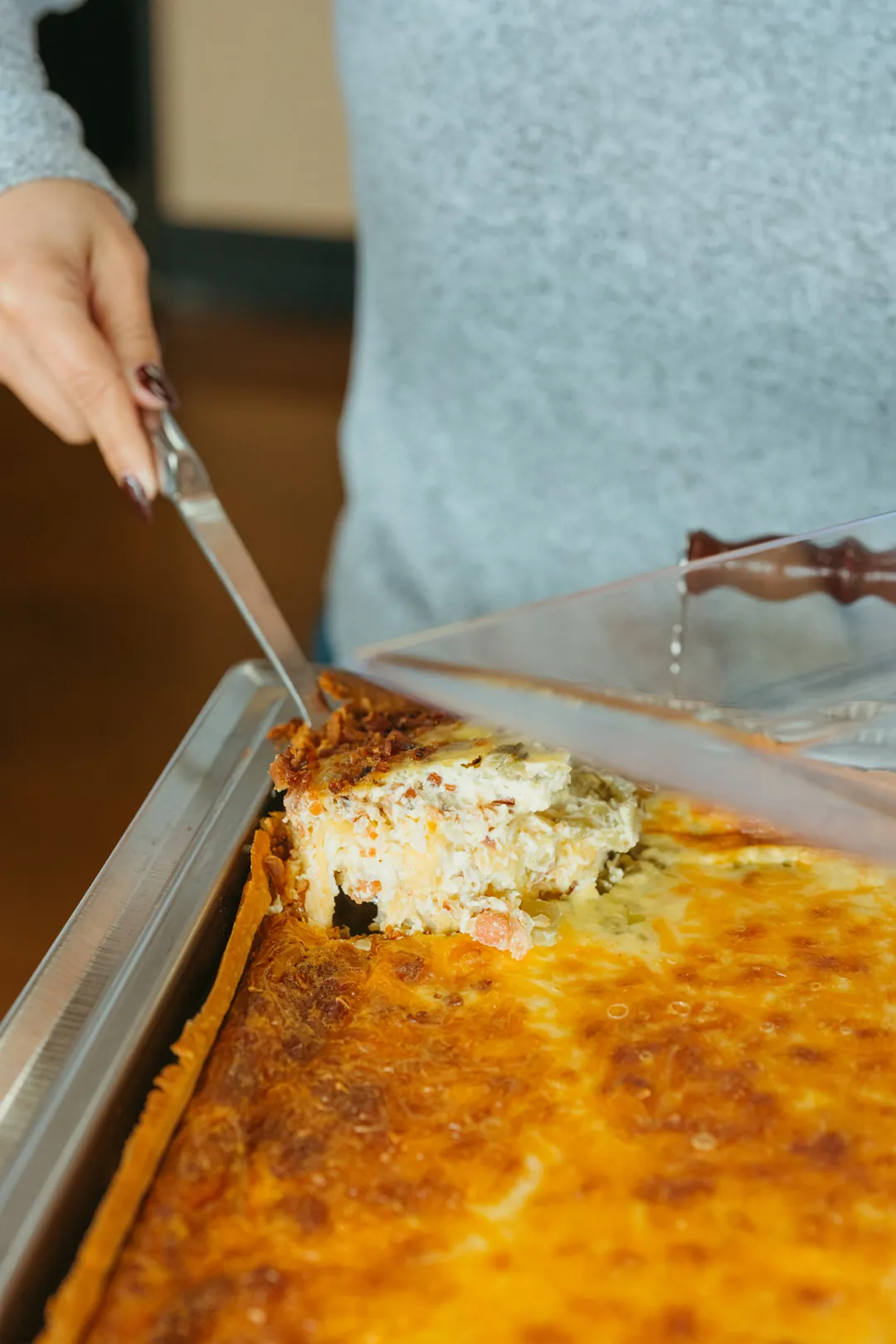 Guest serving a slice of deep-dish quiche