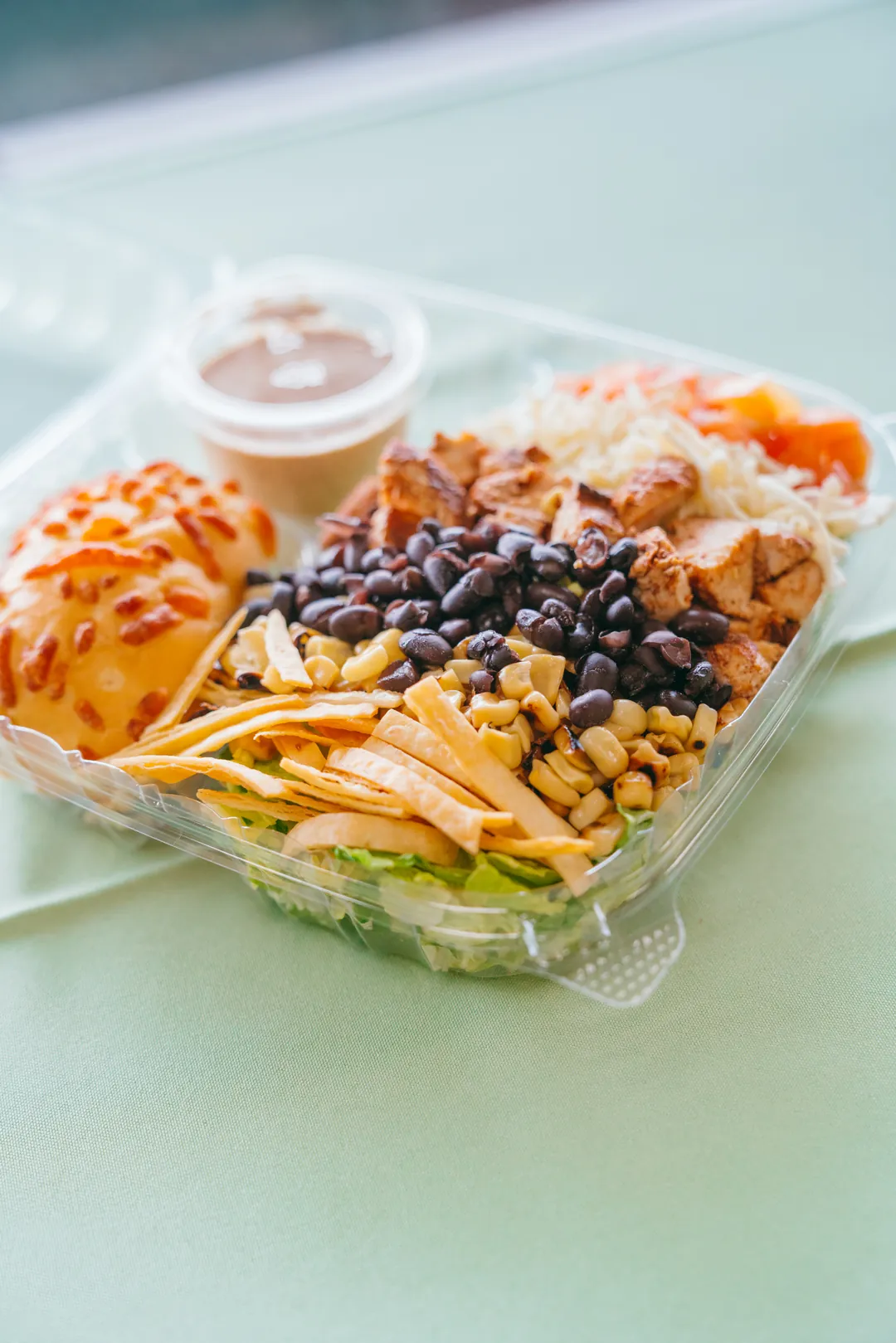 Santa Fe salad with grilled chicken, beans, corn, tortilla strips, cheese and a roll
