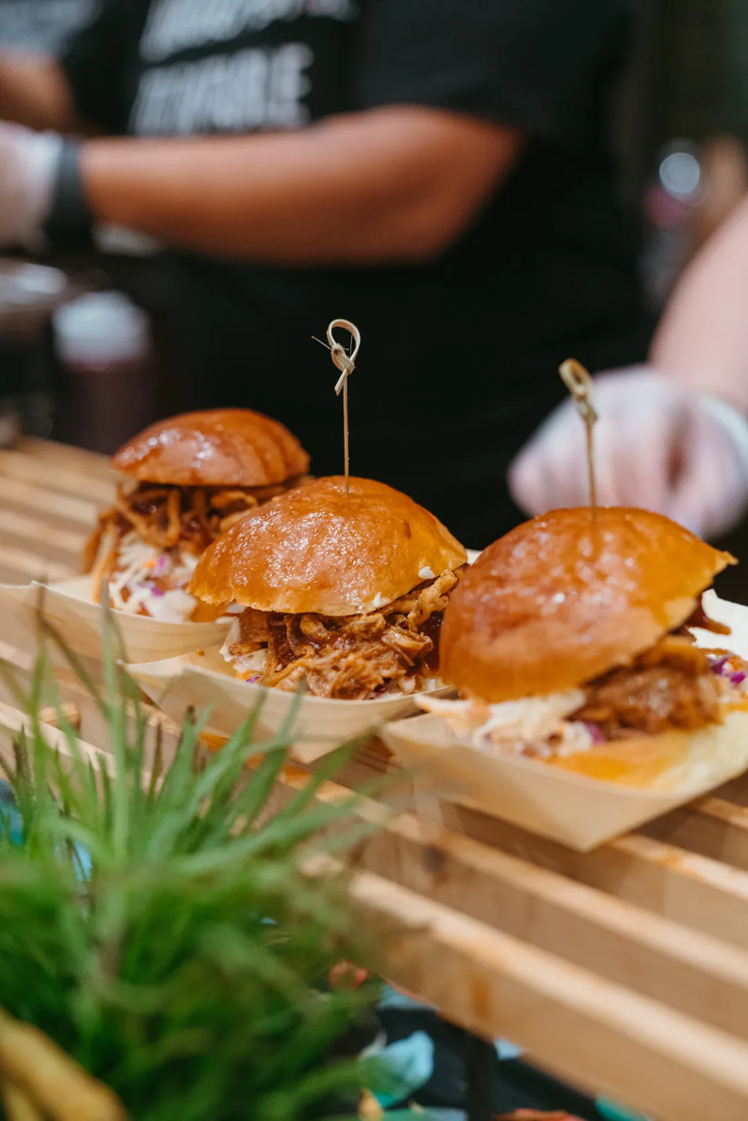 Kalua pulled pork sliders arranged on a wooden display