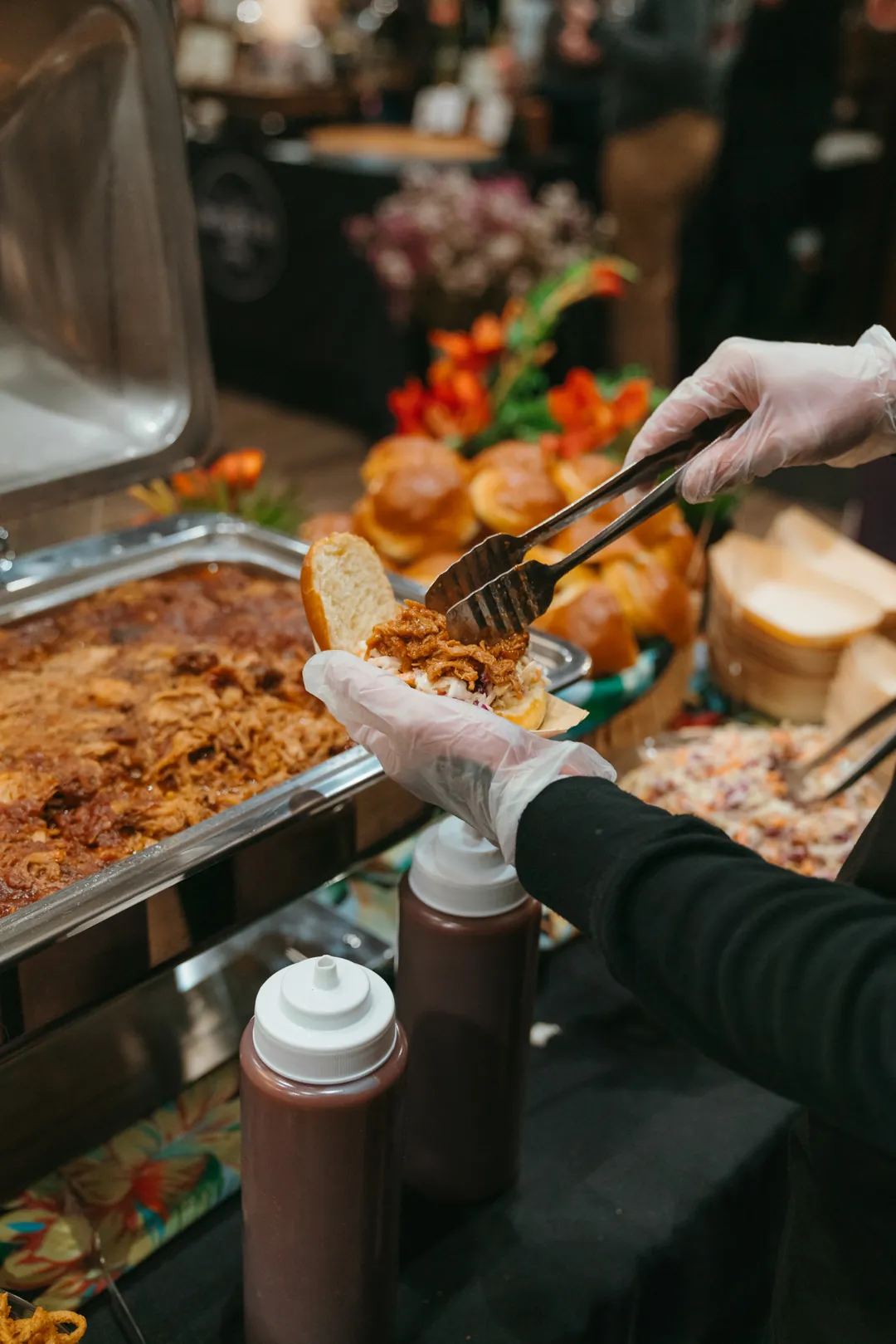 Server filling a Kalua pulled pork slider