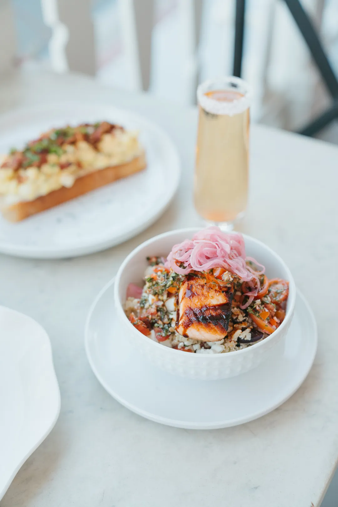 Greek quinoa salmon bowl beside a New Year mimosa