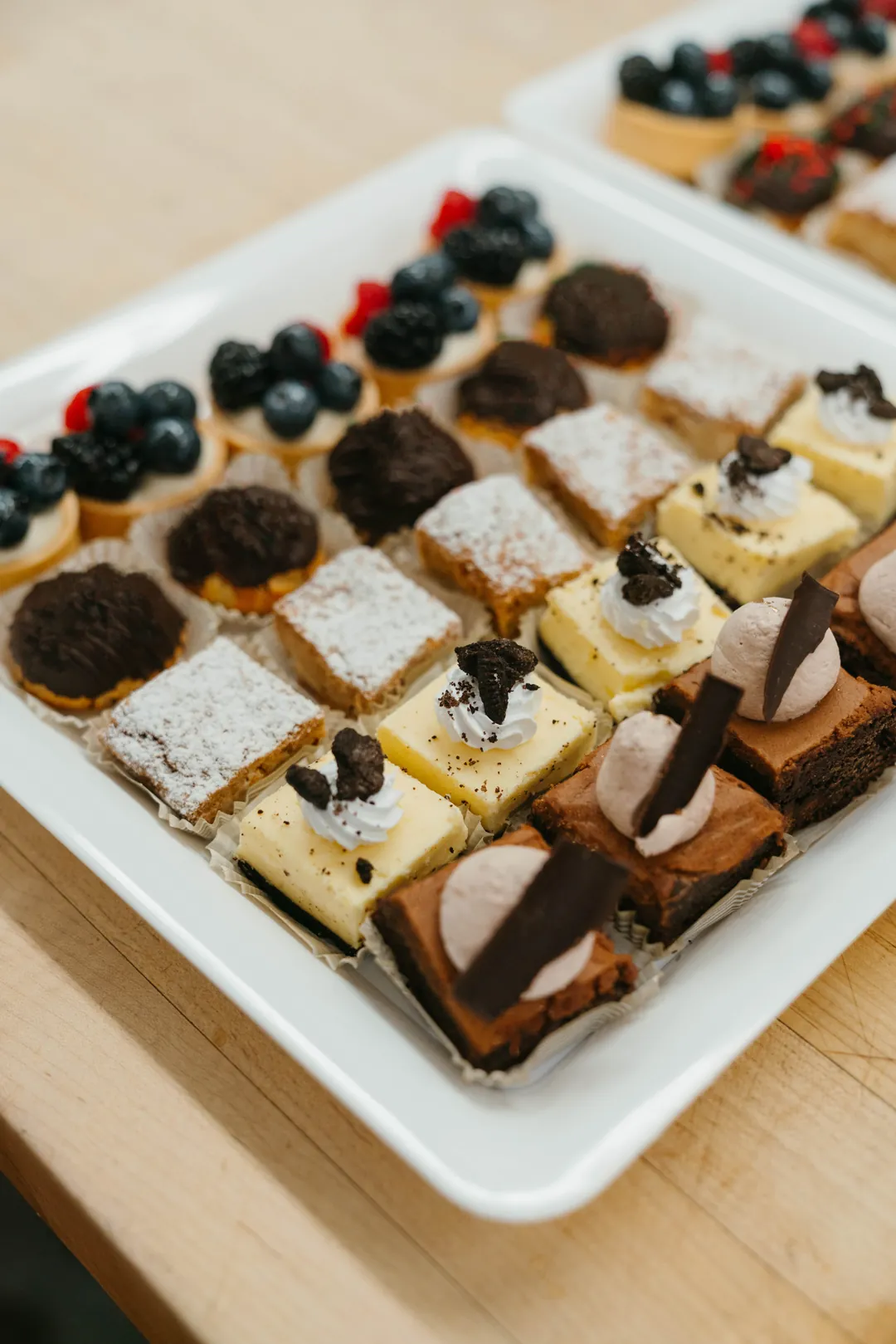 Assorted dessert bars topped with berries and cookies
