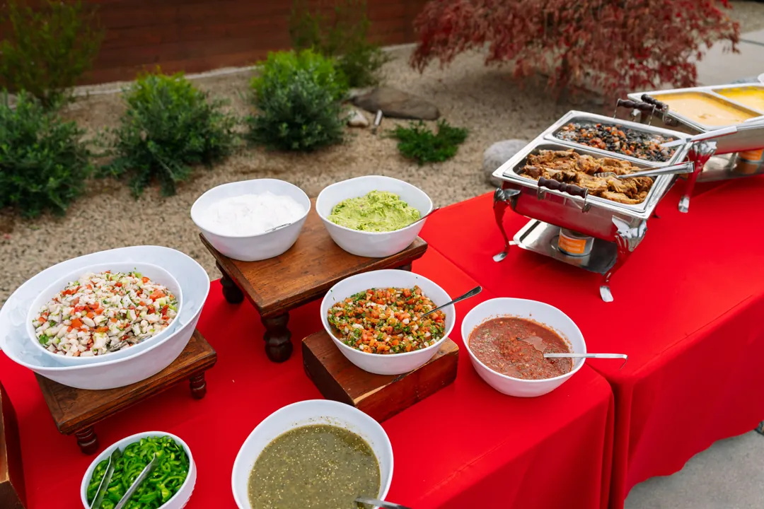 Super Bowl nacho bar with dips, toppings, carnitas, and black beans