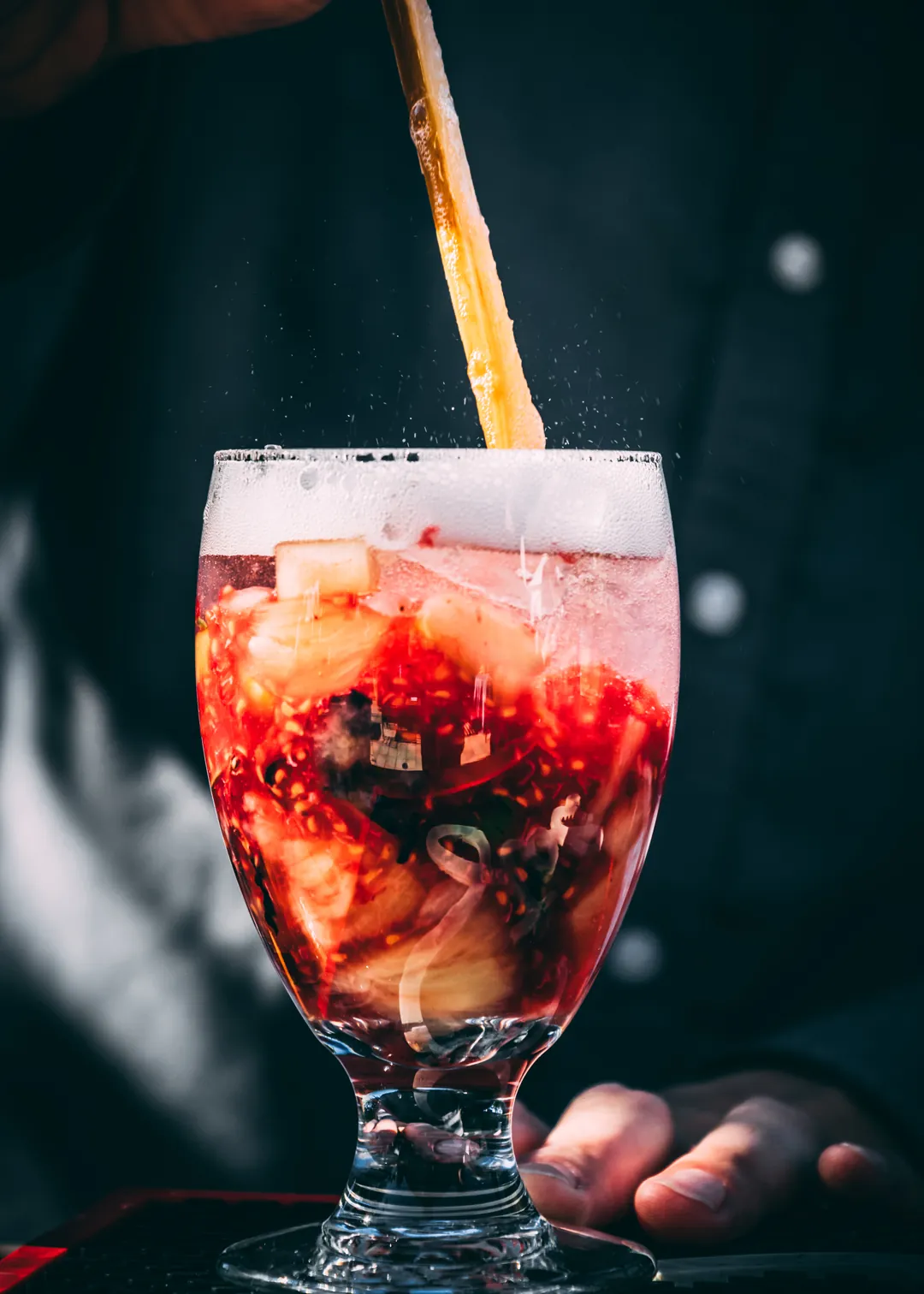 Red holiday cocktail being stirred