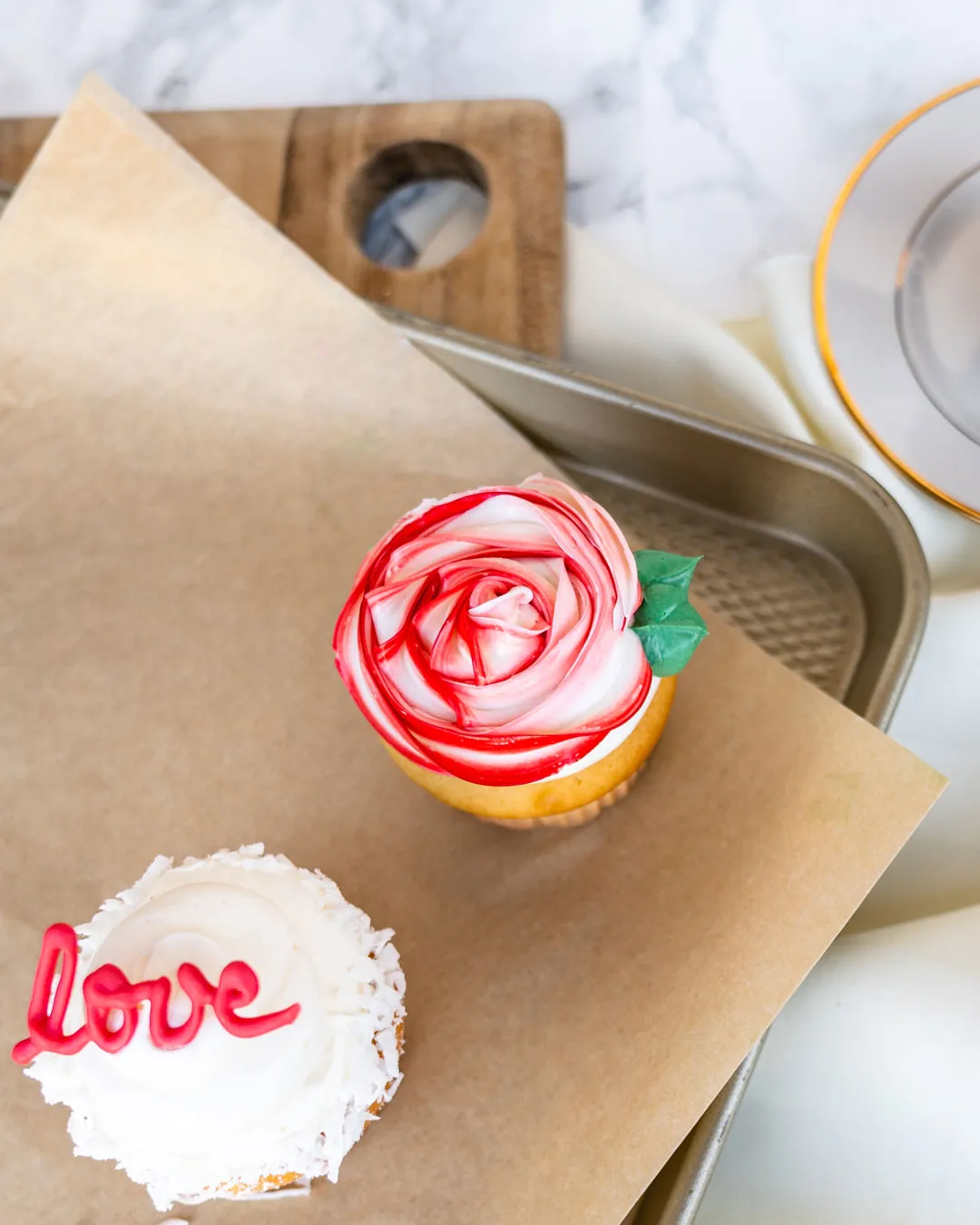Rose cupcake and white love cupcake on a serving tray