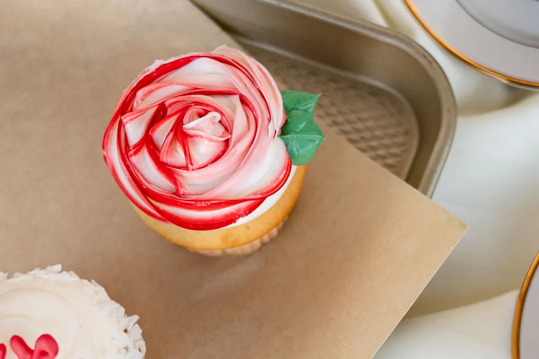 Cupcake topped with a red and white buttercream rose