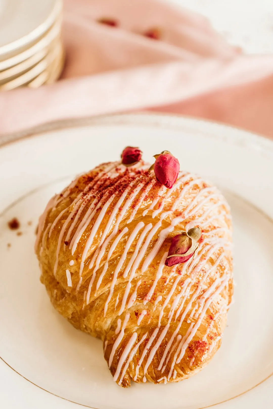 Raspberry rose croissant drizzled with white glaze