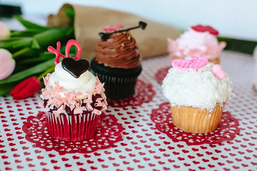 Three Valentine cupcakes with heart and lips decorations