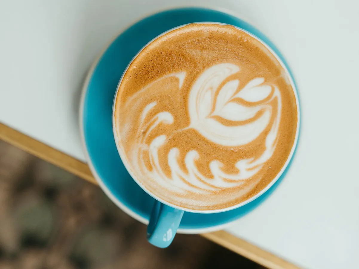 Latte art in a turquoise coffee cup