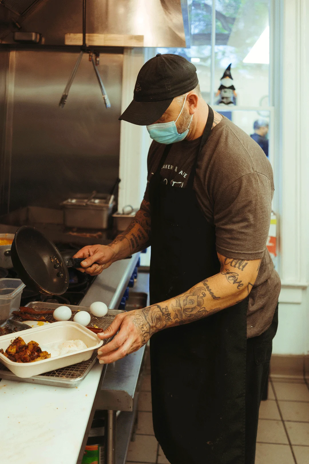 Chef Ken plating an egg-topped breakfast dish