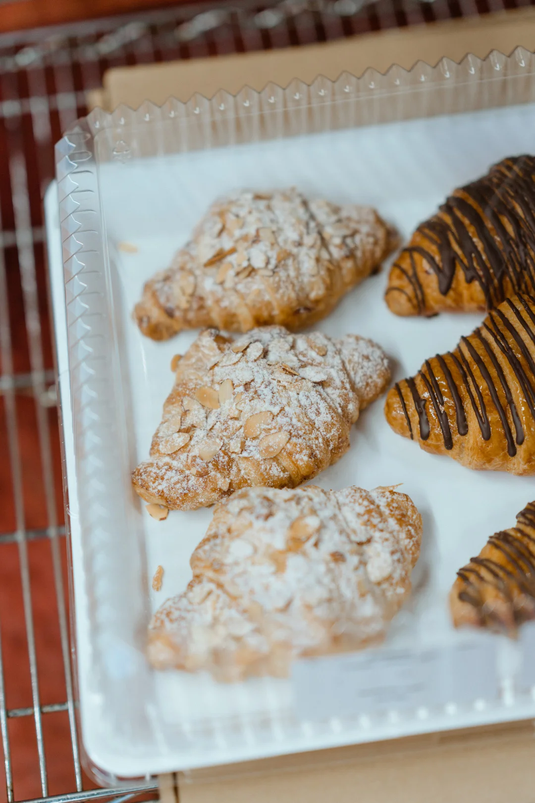 Almond croissants and chocolate-drizzled pastries in the bakery case