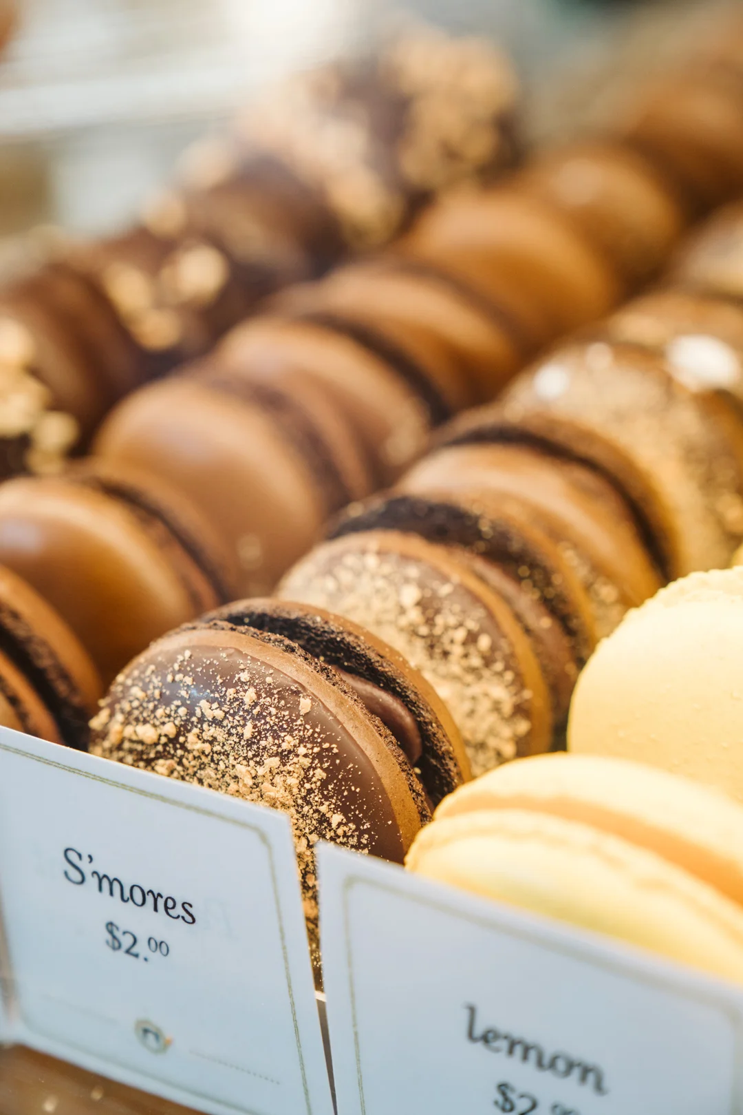 Rows of chocolate and lemon macarons in the pastry case