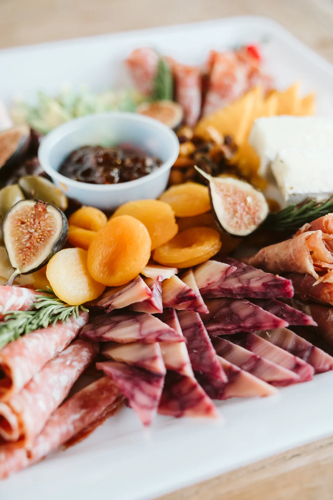Charcuterie board with cured meats, cheeses, dried fruit, figs and olives