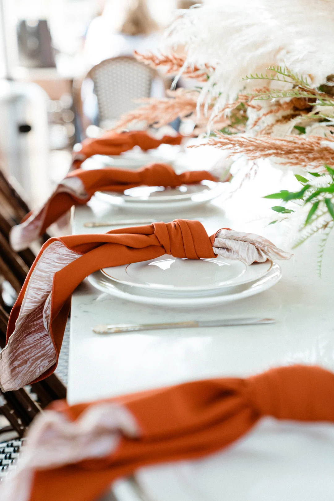 Orange napkins folded at a white place setting