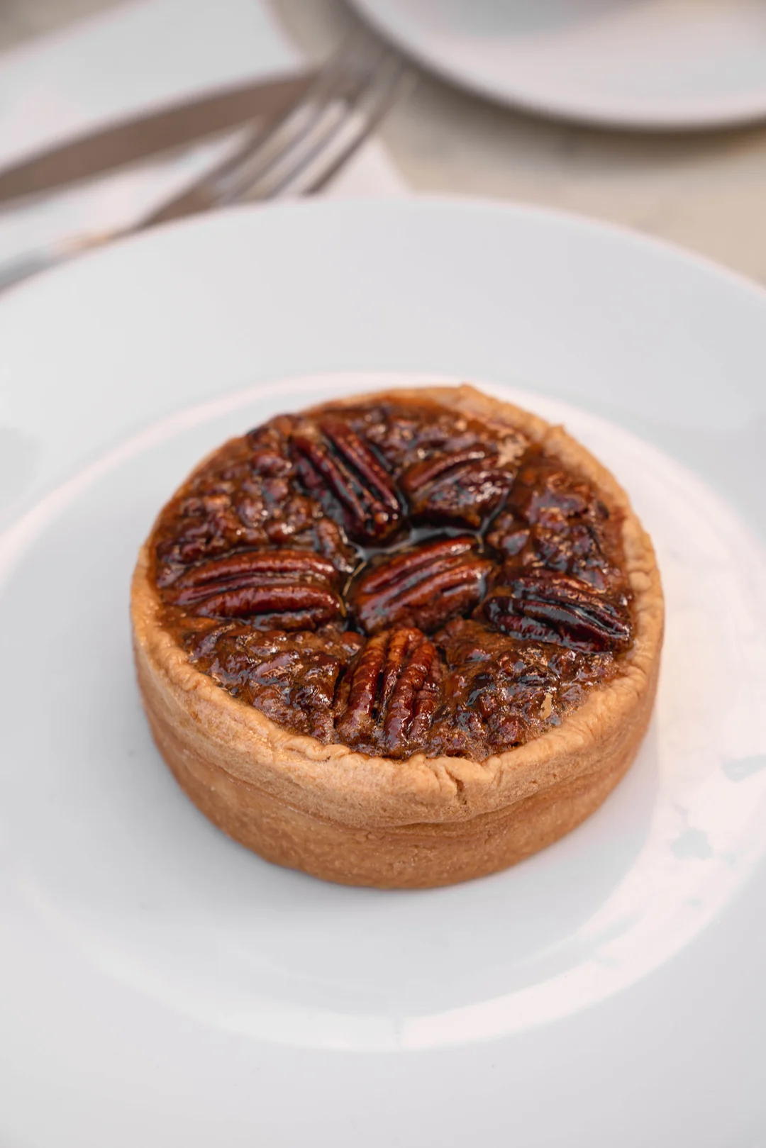 Whole pecan crostata on a white plate