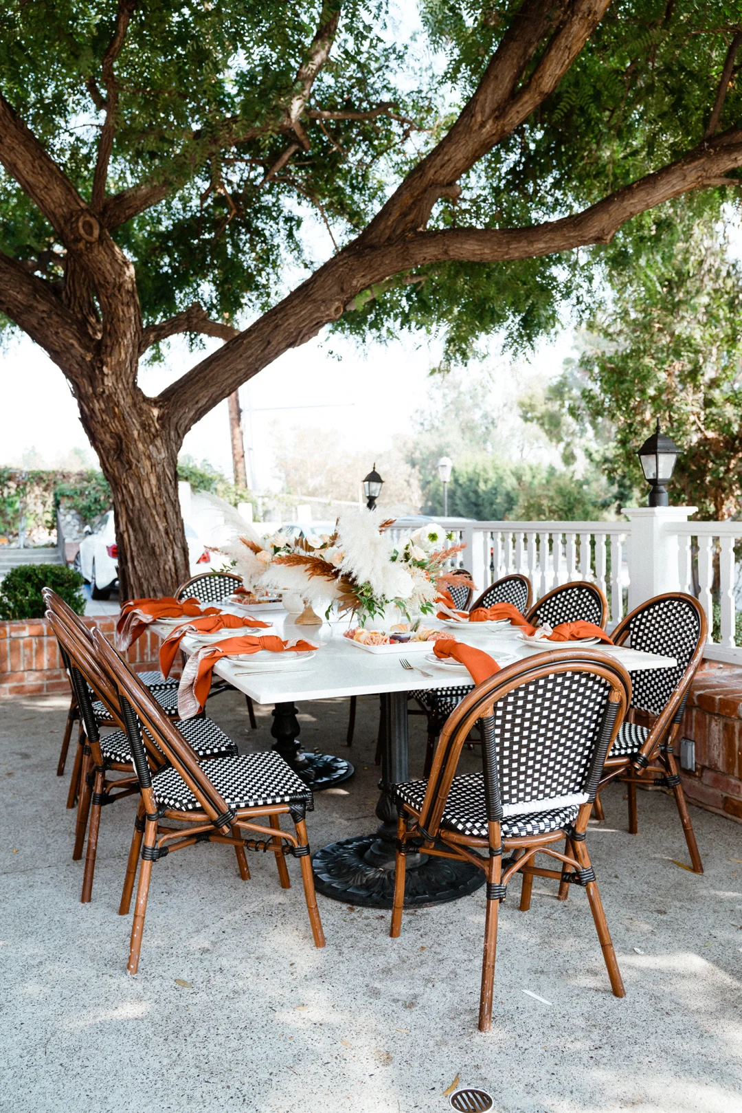 Reserved outdoor table decorated beneath a shade tree