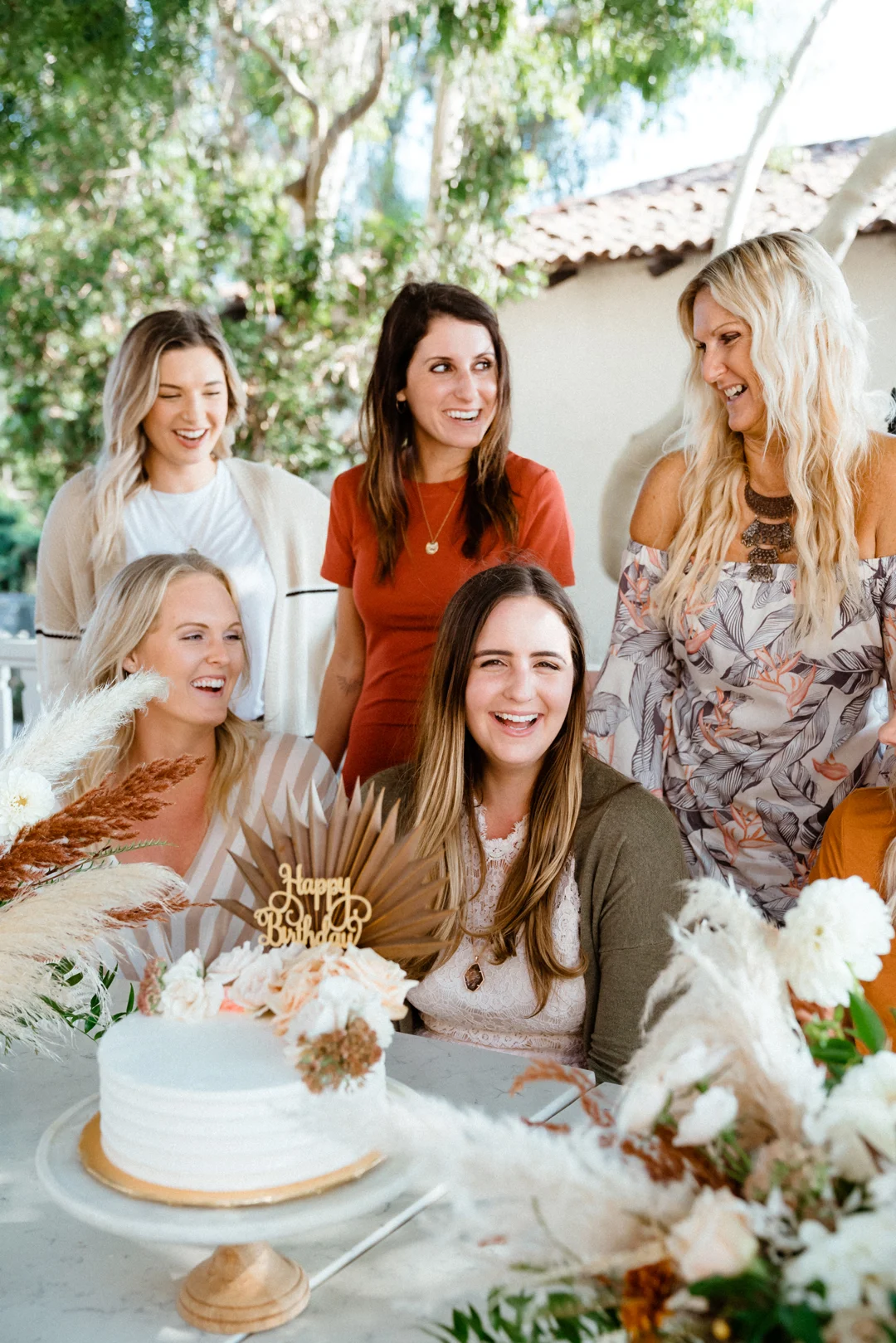 Friends gathered around the celebration cake